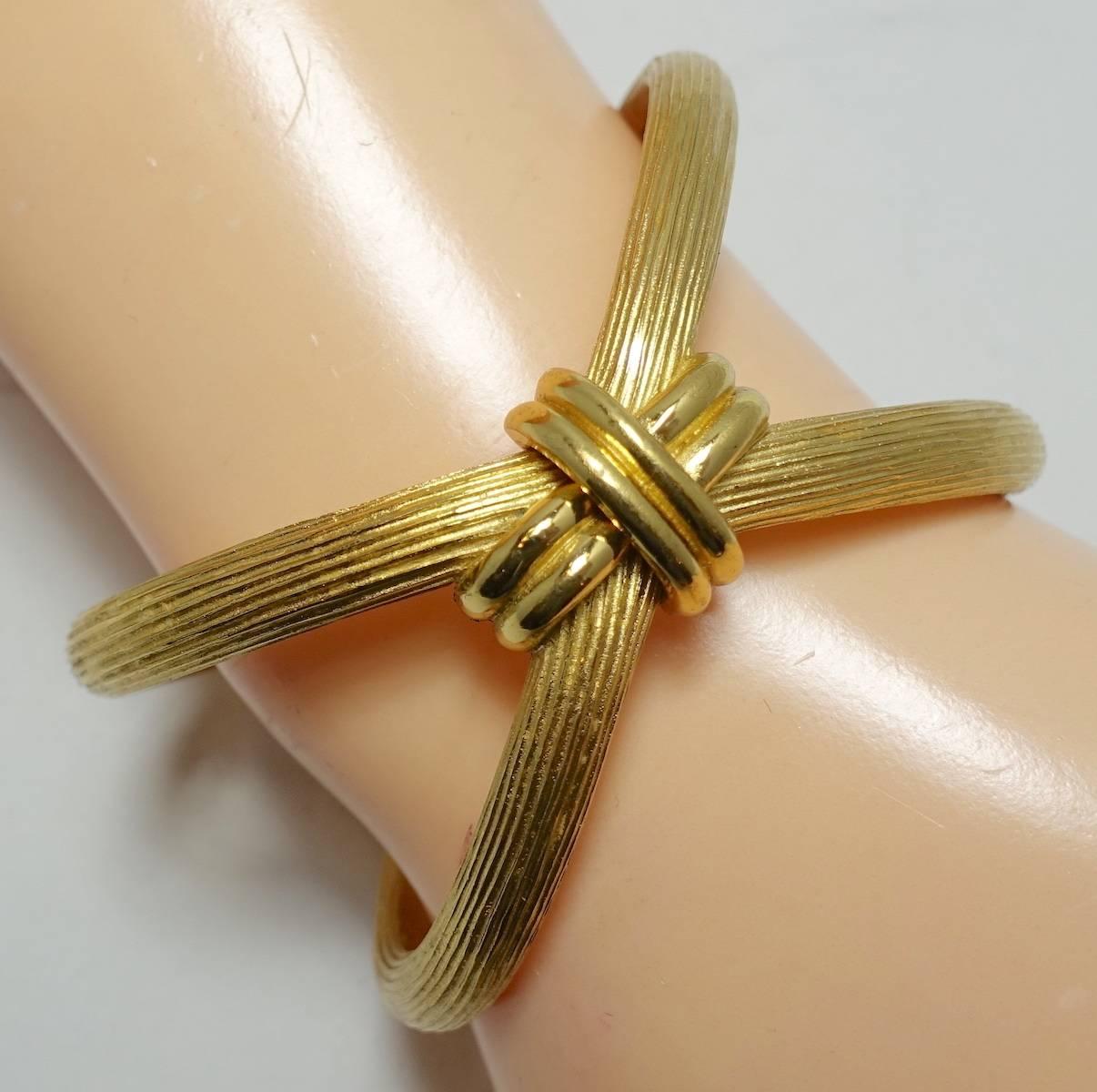 This unique1960s Trifari bracelet features an unusual, abstract modernist design in a gold tone setting.  The bracelet measures 7-1/2” x 1/8” and is signed “Trifari”.  It is in excellent condition.