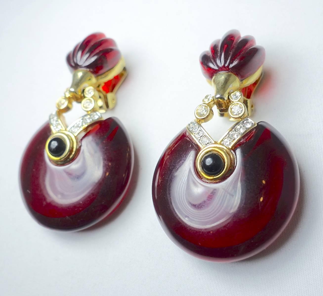 These vintage 1980s French earrings feature a cranberry color resin with clear crystal accents and a round black crystal in the center.  These clip earrings are made in a gold tone setting and measure 2-1/2” x 1-1/4” and are in excellent condition.