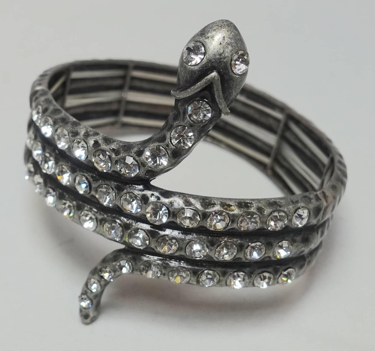 This is the second bracelet. This dramatic bracelet features a snake-serpent design with clear crystals in a heavily carved silver-tone setting.  In excellent condition, this bracelet measures 7-1/4” around the inside x 3/4” around the wrist.