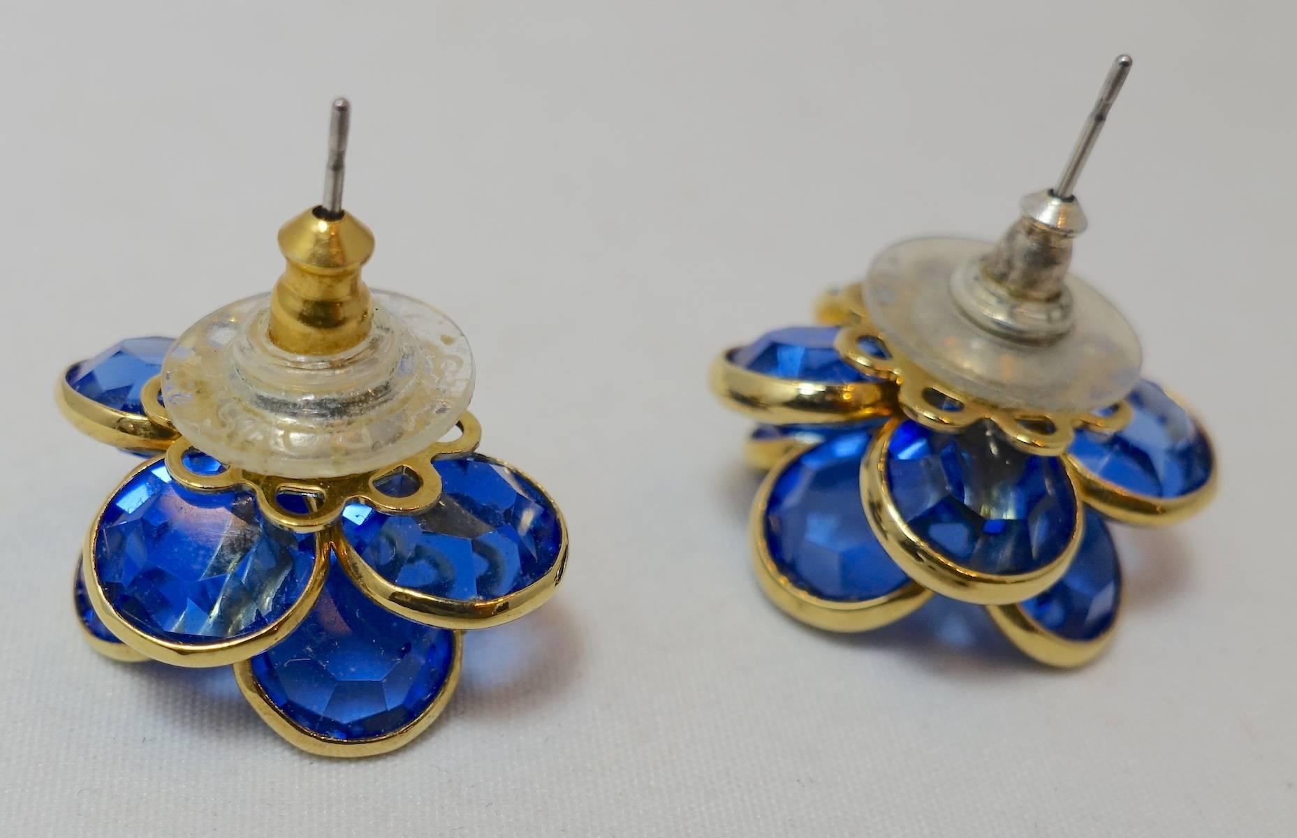 These beautiful vintage earrings feature faceted blue crystals in a floral design.  These pierced earrings measure 3/4” across and are in excellent condition.