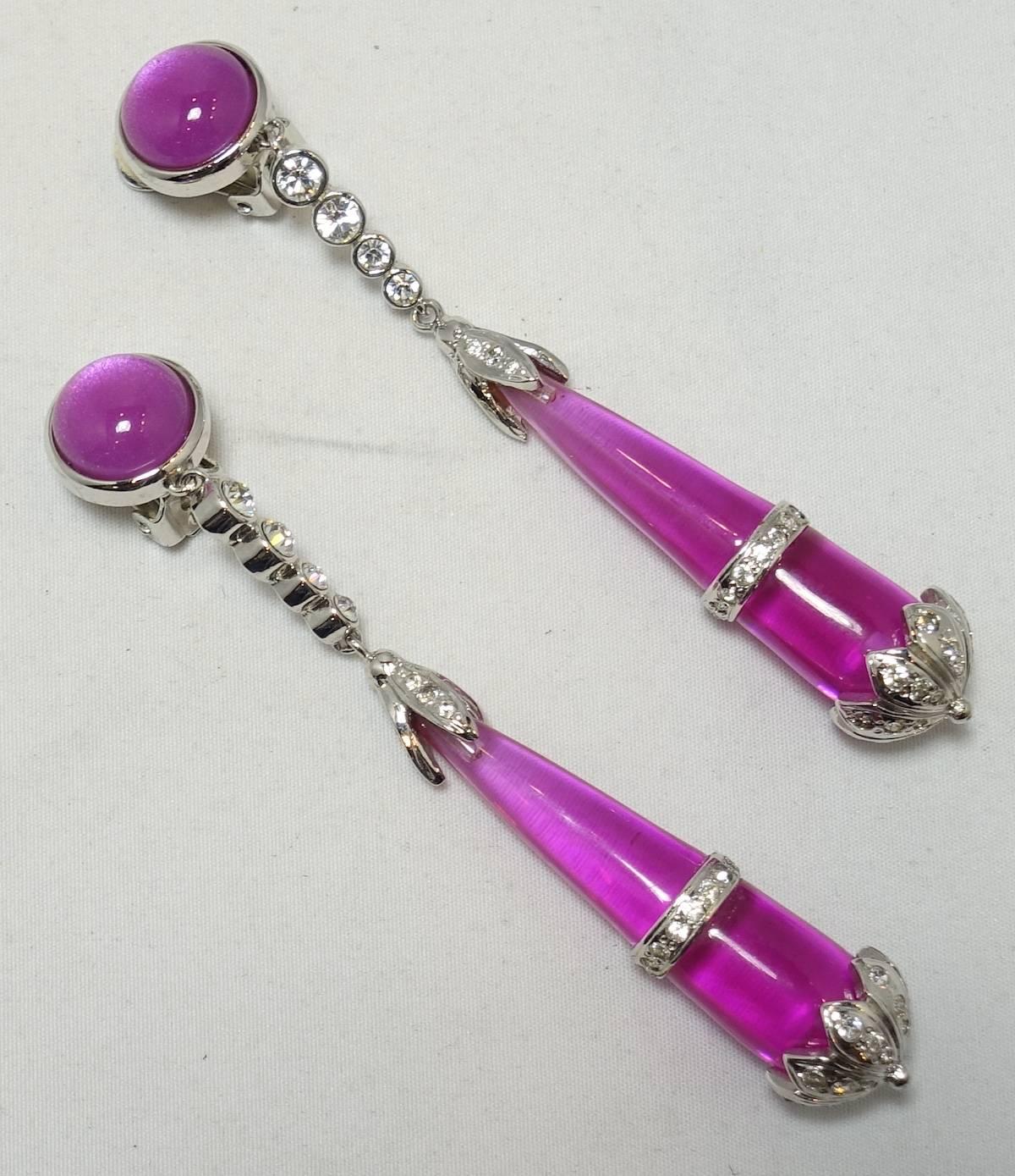 These stunning earrings feature a teardrop design with hot pink resin accented by clear crystals in a silver tone setting.  These clip earrings measure 4” x 1/2” and signed “Replica Made In Italy”.  They are in excellent condition.