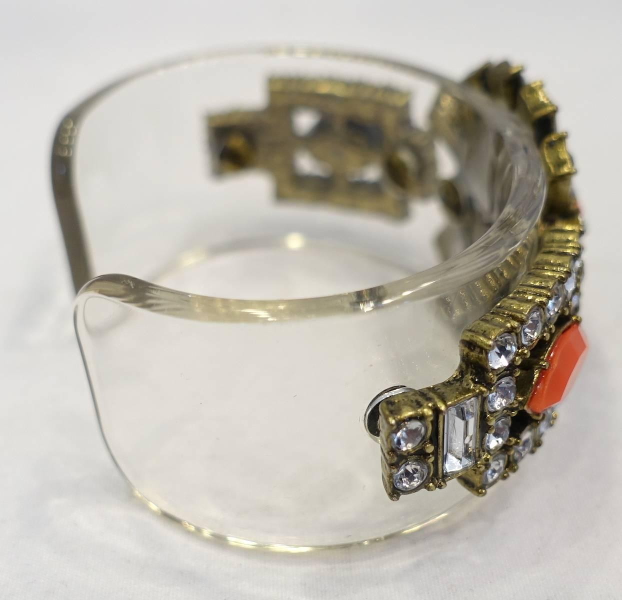 This deco style vintage 1960s bracelet is designed with faux coral surrounded with clear crystals on a Lucite cuff.  This cuff measures 5-1/2” around the inside x 1” and is in excellent condition.