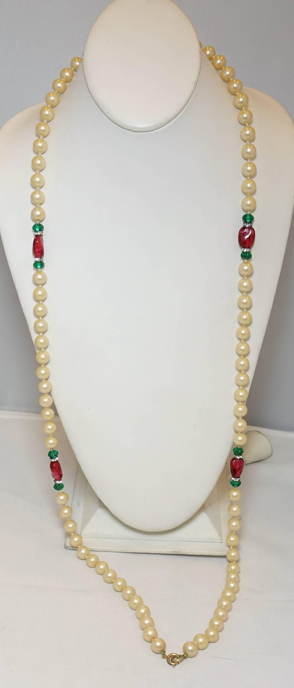 This vintage necklace features red and green French glass and knotted faux pearls with rhondell accents. This necklace measures 42” x 3/8” with a spring closure and is in excellent condition.
