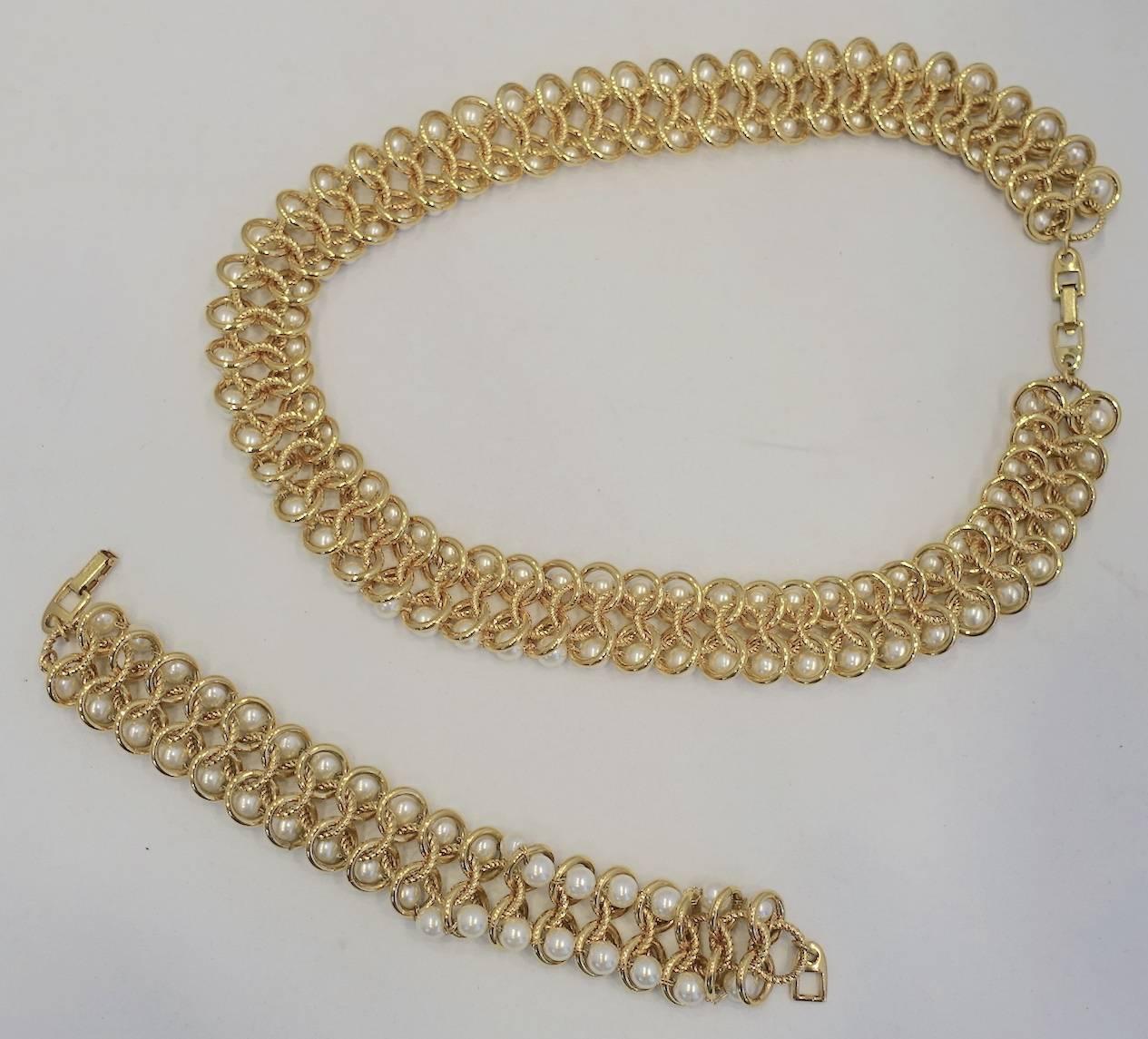 This vintage signed Napier set features faux pearls in a gold tone setting.  The necklace measures 18-3/4” x 7/8” with a fold-over clasp. The matching bracelet measures 7-3/4” x 1” with a fold-over clasp.  This set is signed “Napier” and in