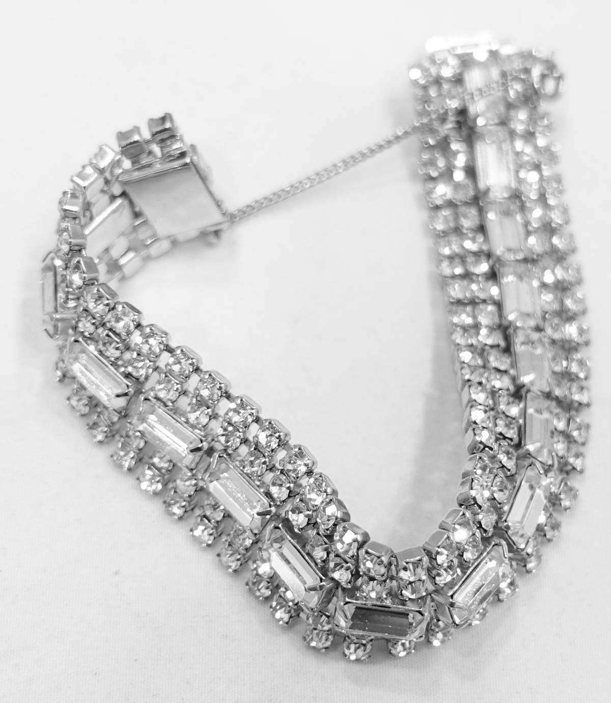 This vintage 1950s bracelet features brilliant clear crystals in a rhodium silver tone setting.  In excellent condition, this bracelet measures 7-3/8” x 3/4” and has a slide in closure.