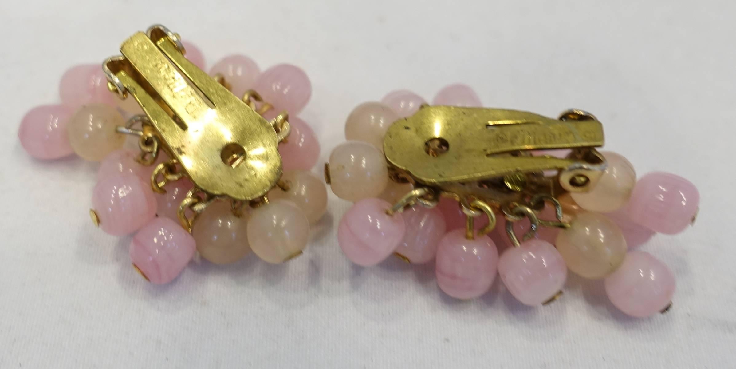 These vintage signed DeMario earrings feature pink glass beads in a gold tone setting.  These clip earrings measure 1” x 1” and are signed “DeMario”. They are in excellent condition.