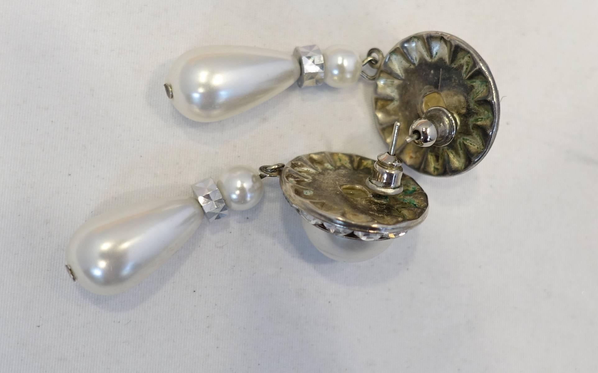 These classic earrings are designed with faux pearls and clear crystal accents in a silver tone setting.  These pierced earrings measure 2” x 3/4” and are in excellent condition.