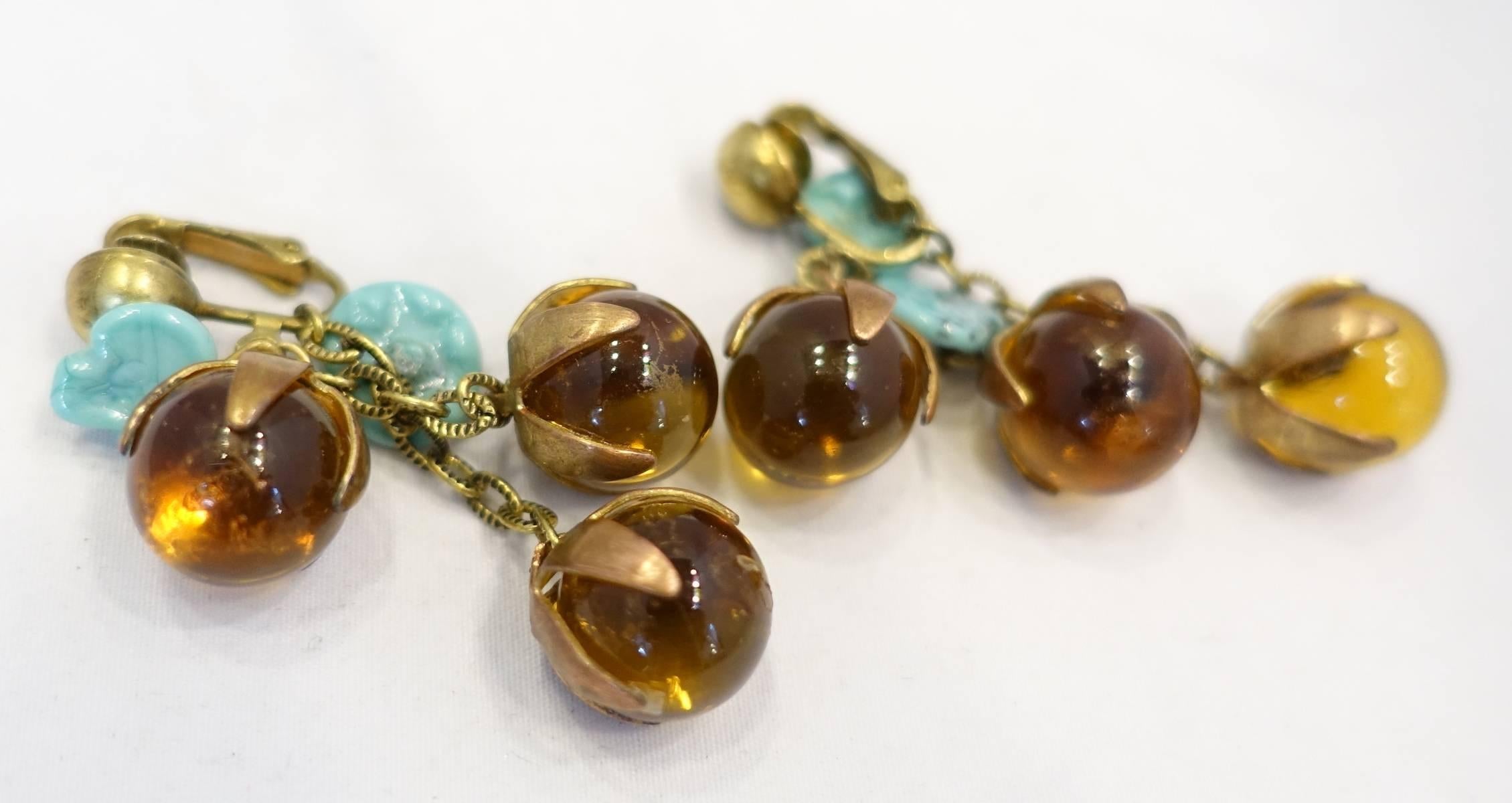 These vintage deco earrings feature amber and turquoise leaves glass beads in a gold tone setting.  These clip earrings measure 2-1/4” x 1” and are in excellent condition.