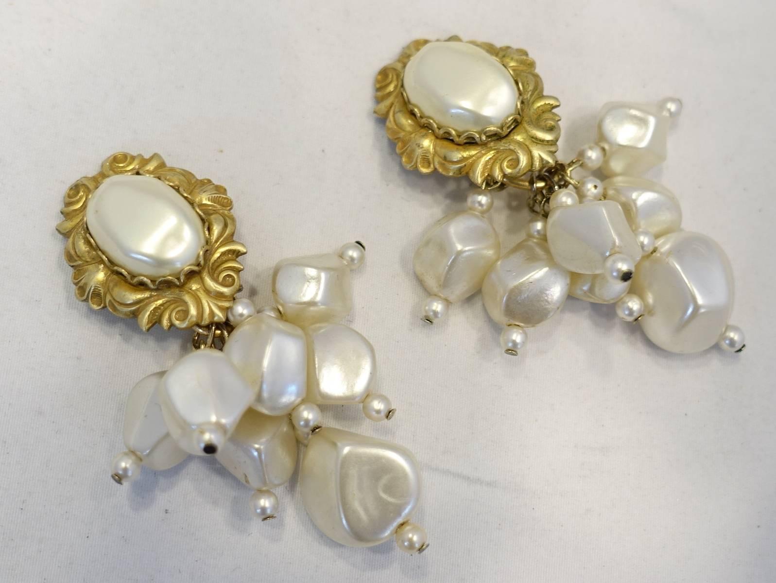 These vintage signed DeMario earrings feature faux pearls in a gold tone setting. These clip earrings measure 2-5/8” x 1-1/2” and are signed “DeMario”. They are in excellent condition.