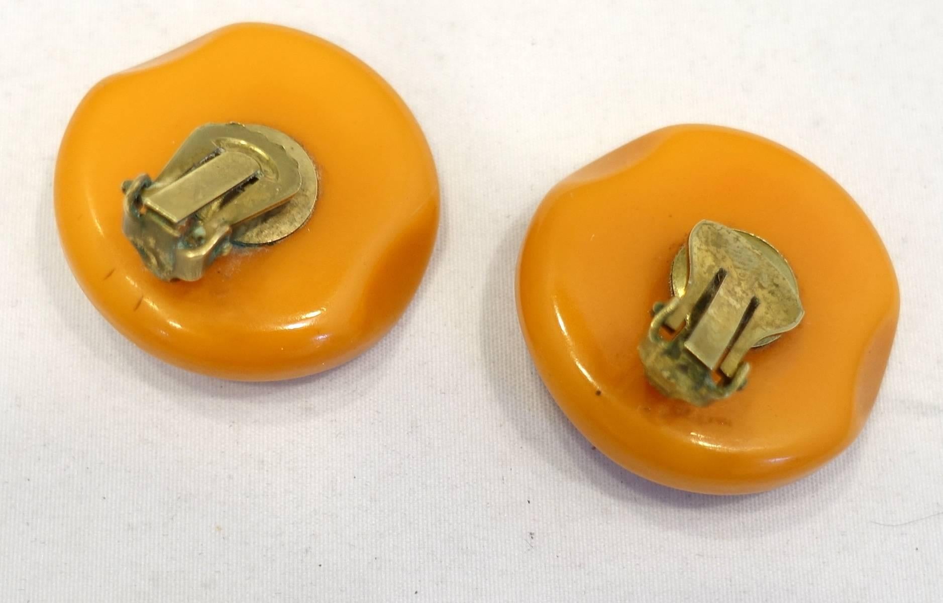 These vintage round 1930s earrings is made of butterscotch Bakelite with a gold-tone setting. These clip earrings measure 1-1/4” and are in excellent condition.