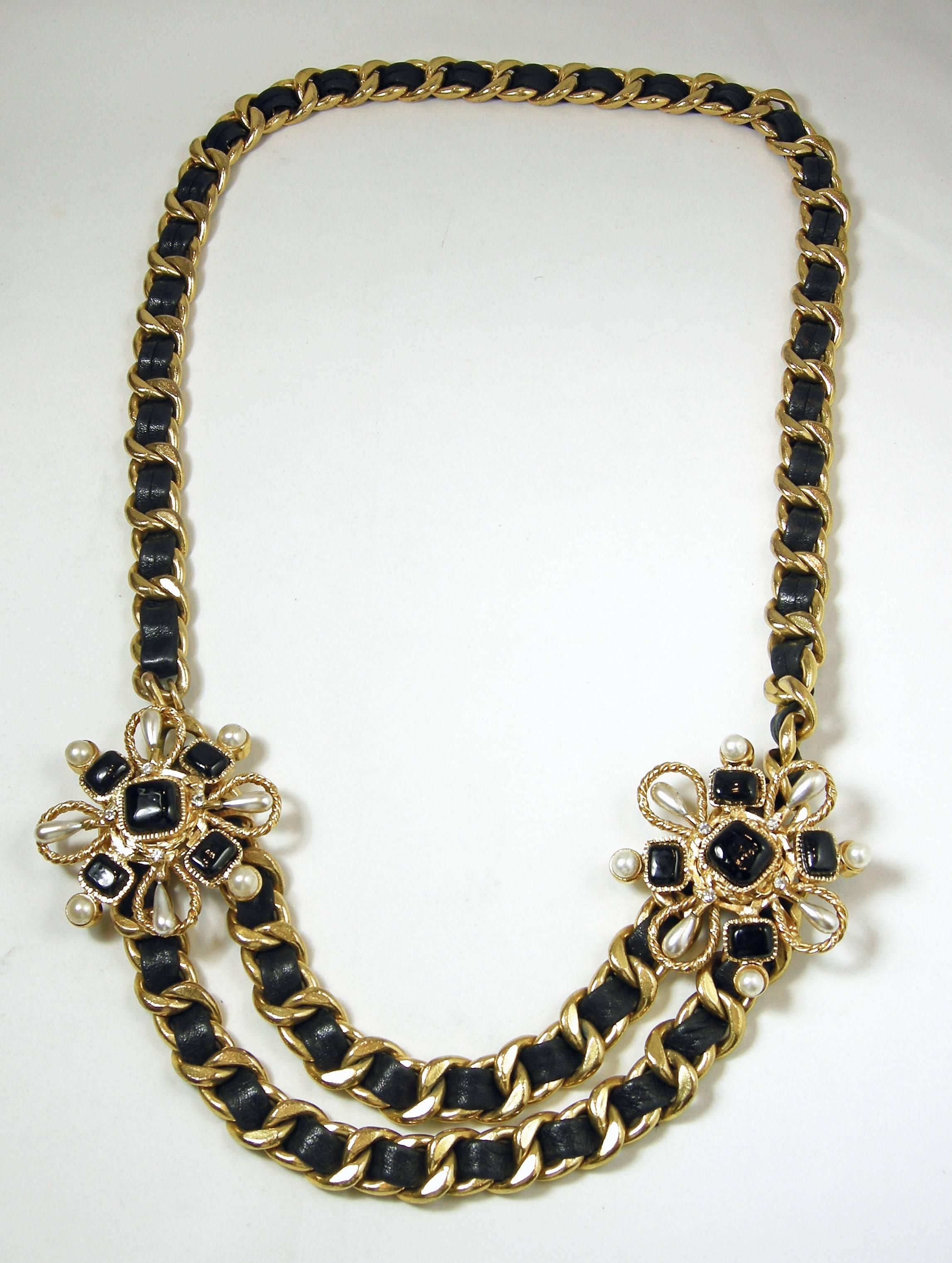 This is a special couture vintage Chanel necklace with Chanel’s famous leather ribbon through the gold tone links. It has two layers at the bottom met by two floral black Gripoix squares and pearls spearing outward on each side. It has a hook clasp