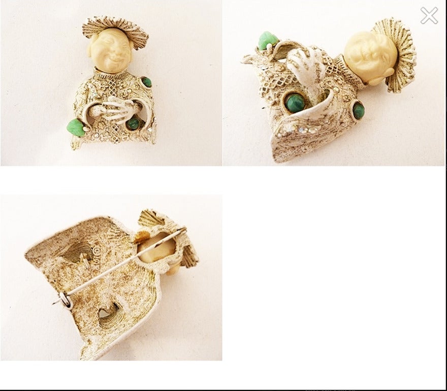 This vintage signed Har pin feature a Buddha design with green cabochon stones and clear rhinestones in a white-washed metal setting. This pin measures 2 ¼” x 1 ½” with a turn closure, is signed Har and is in excellent condition.