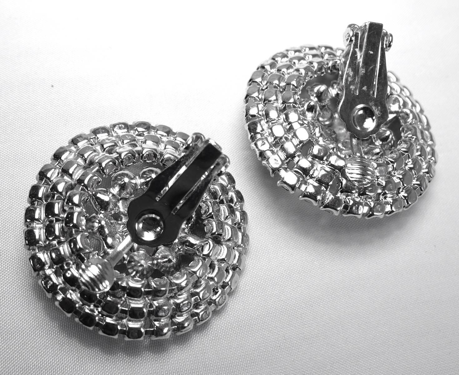 These large statement earrings feature clear crystals in a silver tone setting.  These clip earrings measure 1-1/2” x 1-1/2” and are in excellent condition.