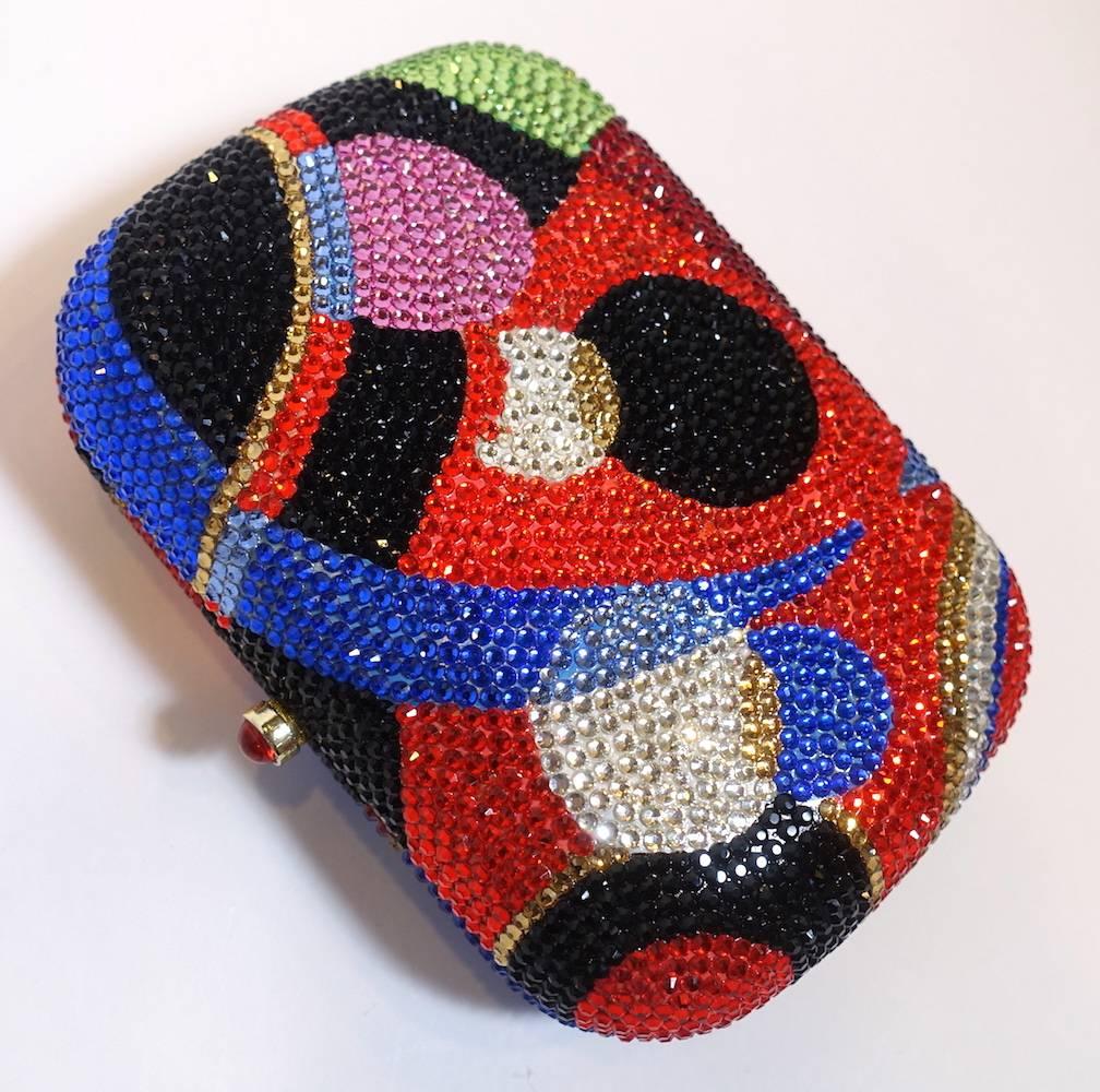 This beautiful evening bag features multi-color rhinestones with gold-plated metal accents and chain.  In excellent condition, this purse measures 6” long x 4-1/2” wide x 1-7/8” deep.  The gold tone shoulder chain is 25” up from center. It is in