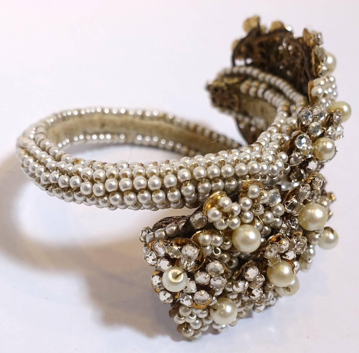 This early vintage Miriam Haskell wrap bracelet features faux pearls with crystal accents in a gold-plated base metal setting.  In excellent condition, this Miriam Haskell bracelet unwraps to approx. 10” and will fit a wrist of size 6-7.  The