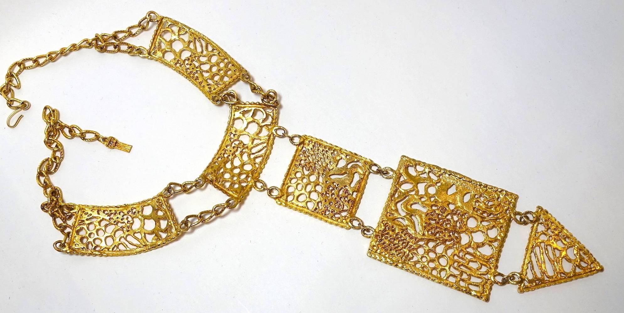 This vintage 1970s necklace features a heavily etched, open-work design in a gold-plated base metal setting.  In excellent condition, this necklace measures 24” with an 11” front drop with a hook closure.  