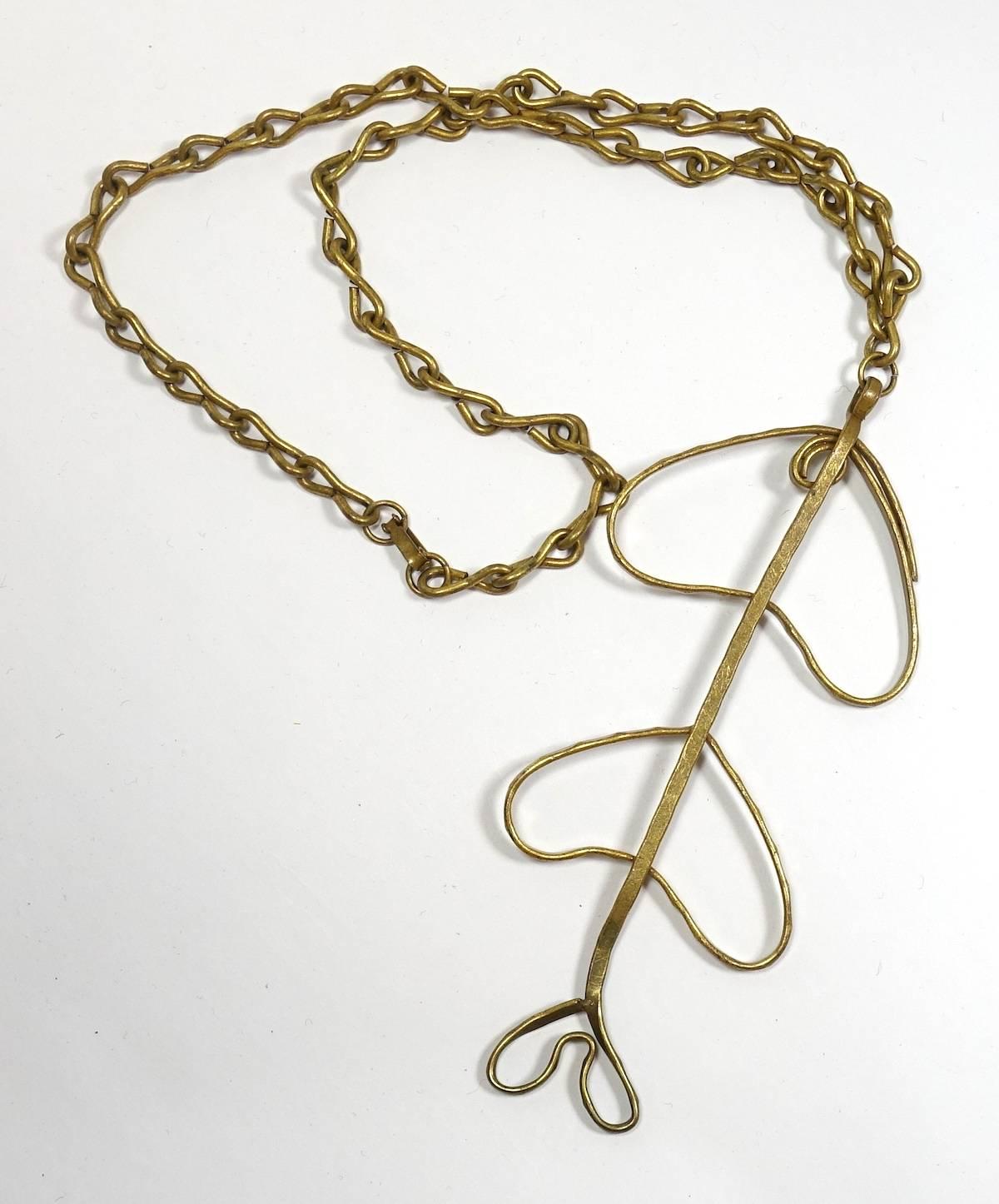 This vintage 1970s necklace features a heavily etched, open-work design in a gold-plated base metal setting.  In excellent condition, this necklace measures 24” with an 11” front drop with a hook closure.  