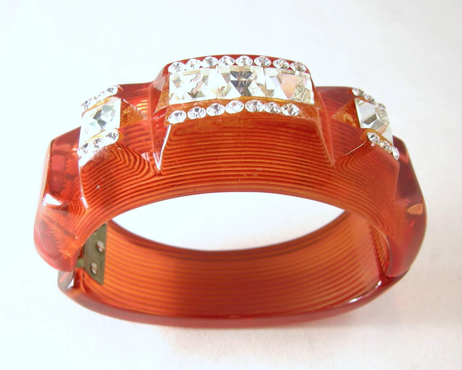 It’s not often one can find this rare red apple juice Bakelite bracelet, especially adorned with bright, glistening crystals in the center and the sides.  It is just magnificent.  It is 1” high and 6” inside.  It is a clamper bracelet and in