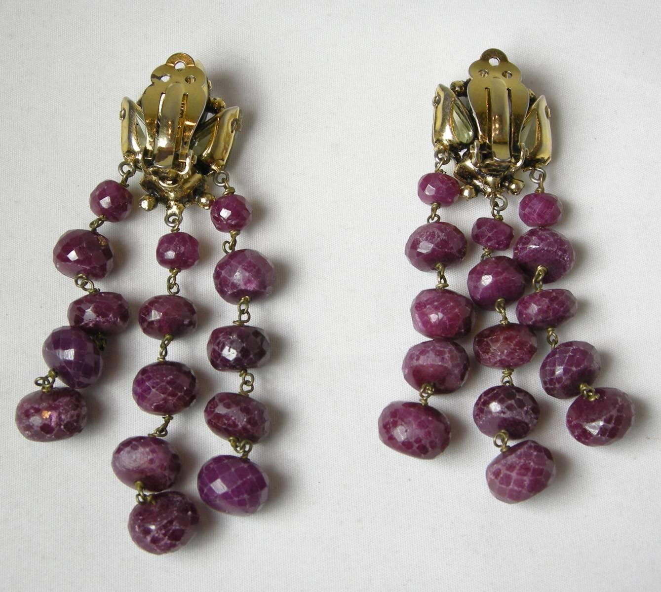 These vintage Iradj Moini gemstone earrings are gorgeous.  The top of these clip earrings have pronged set peridot, amethyst and citrine gemstones accented with tiny crystals.  Dangling down are 3 rows of ruby stones.  They are made with a gold tone