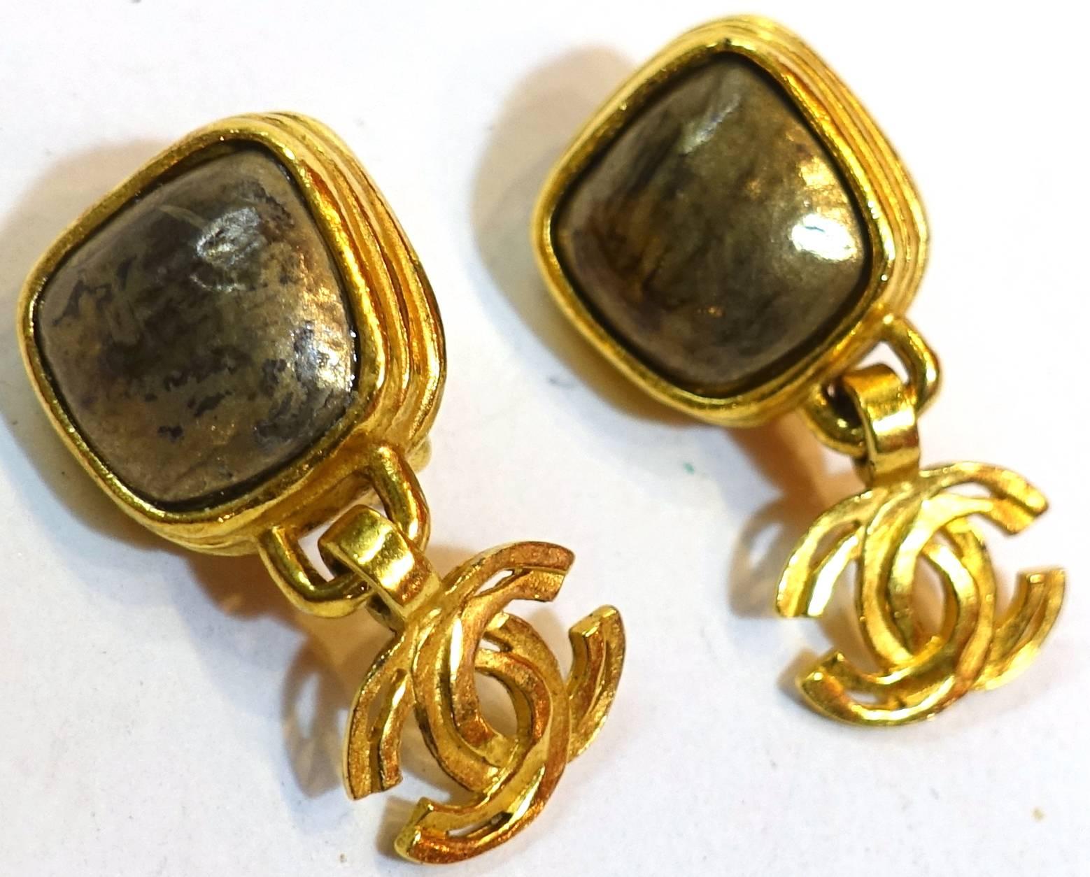 These vintage Chanel clip earrings are very unusual and I believe rare.  The top has a grey iridescent stone bezel in a gold tone ribbed frame.  The double Cs extends down from the frame. They measure 1-1/2” long and 3/4
