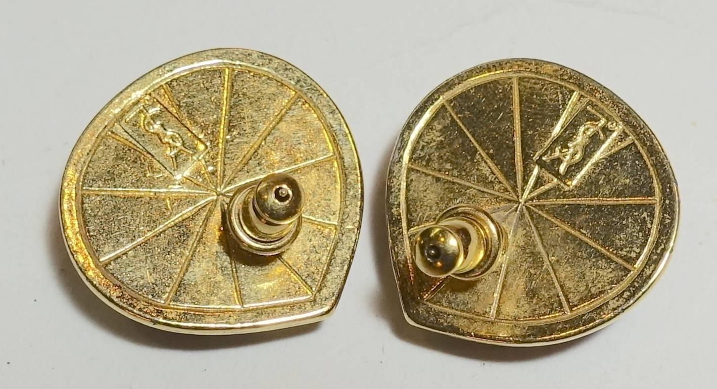 It is not often you find Yves St. Laurent earrings pierced, but these are and they are perfect for the ears.  The center is a blue melon carved stone that is bezel into a gold tone metal setting.  They measure 1” x 1” and signed “YSL” on the back. 