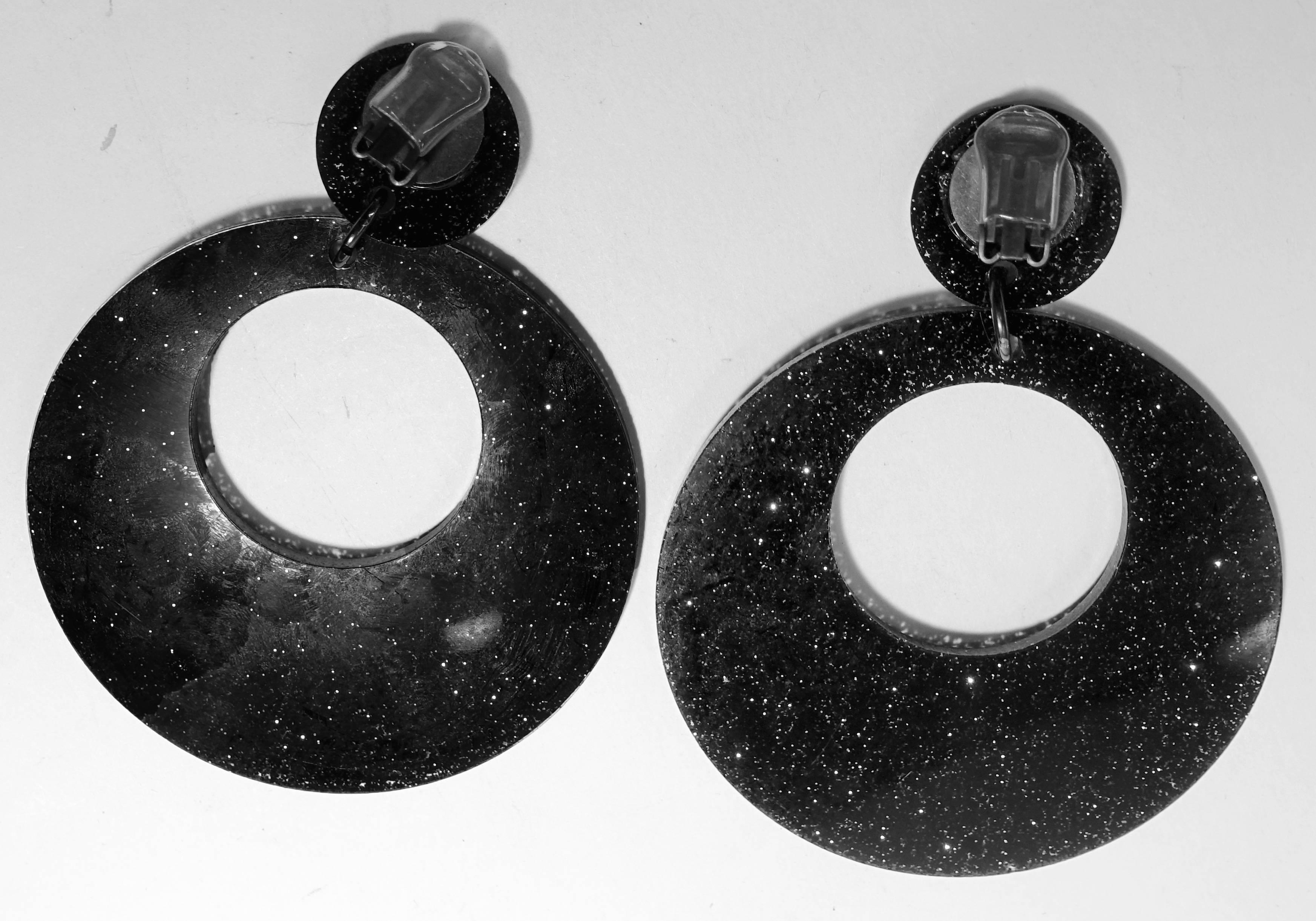 These clip earrings are so campy, I had to buy them in black also.  They each have a black plastic iridescent round disk at the top that connects to a huge dangling black hoop at the bottom. They measure 4-1/8” long and 3-1/4” wide.  You’ll