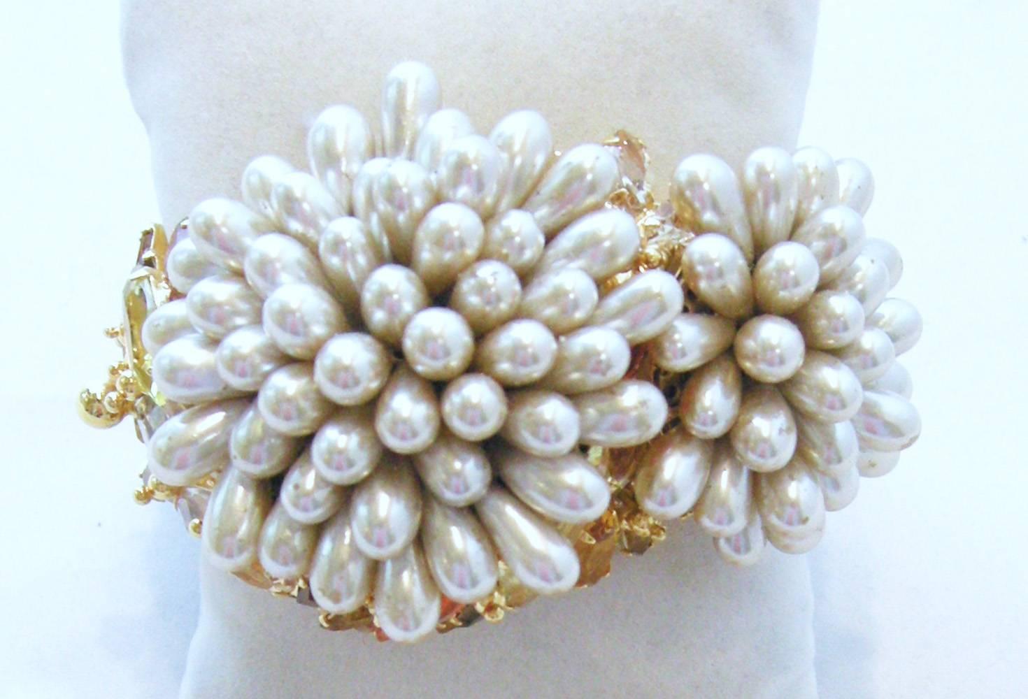 This outstanding Robert Sorrell cuff bracelets has 2 flower beads of vintage glass and pearl teardrops.  Crystals set off by topaz, jonquil and Hyacinth crystals.  It is a spring-hinged cuff with a slide in clasp.  It is 7-1/4” x 1-1/2”.  The center