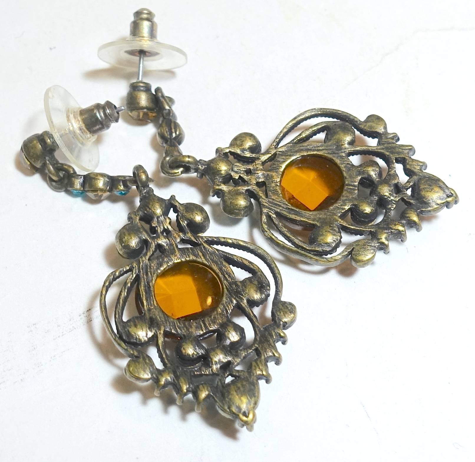 These earrings have a Victorian look to them but I believe they were made in the 60s.  They are pierced with citrine and aqua rhinestone leading down to a decorative center.  The center stone is a faceted citrine rhinestone with aqua and orange