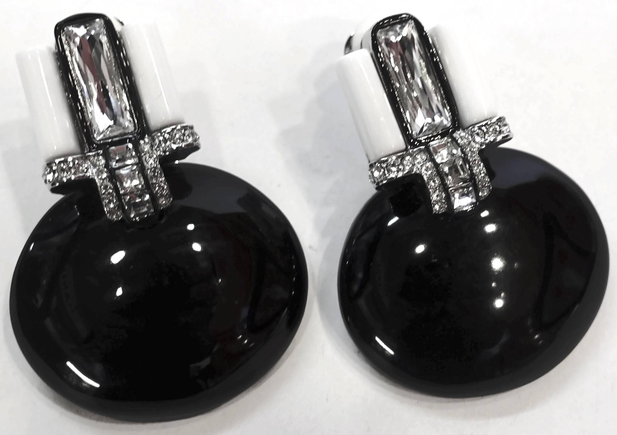 These signed Kenneth Lane earrings feature faux onyx with white enameling with crystal accents in a silver-plated base metal setting. In excellent condition, these clip earrings measure 2” x 1-1/2” and are signed “KJL”.