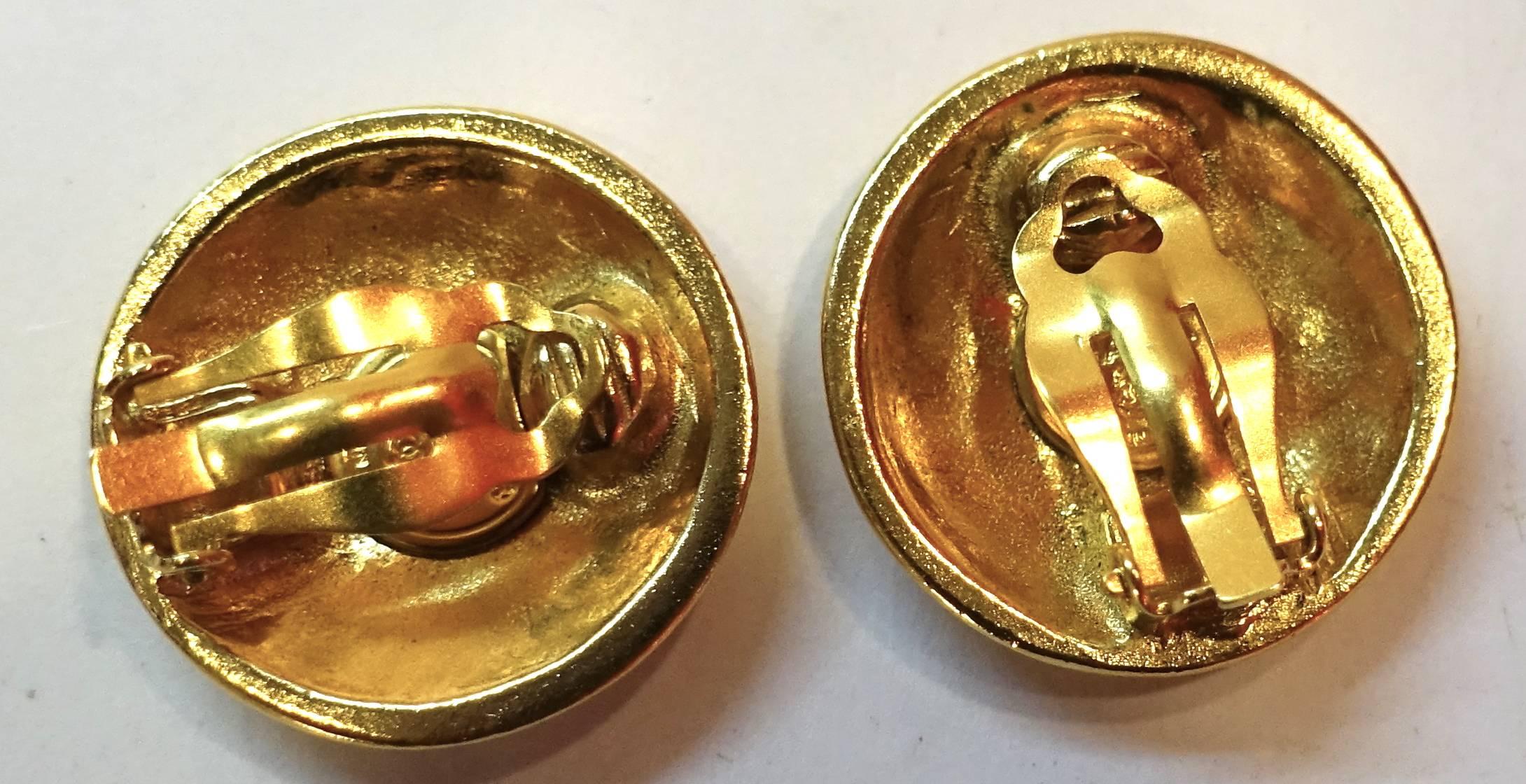 These vintage round Chanel clip earrings have the double Cs intertwined with each other on a gold plated metal finish. They measure 1-1/4” and signed “Chanel Made in France”.  These earrings are in excellent condition.