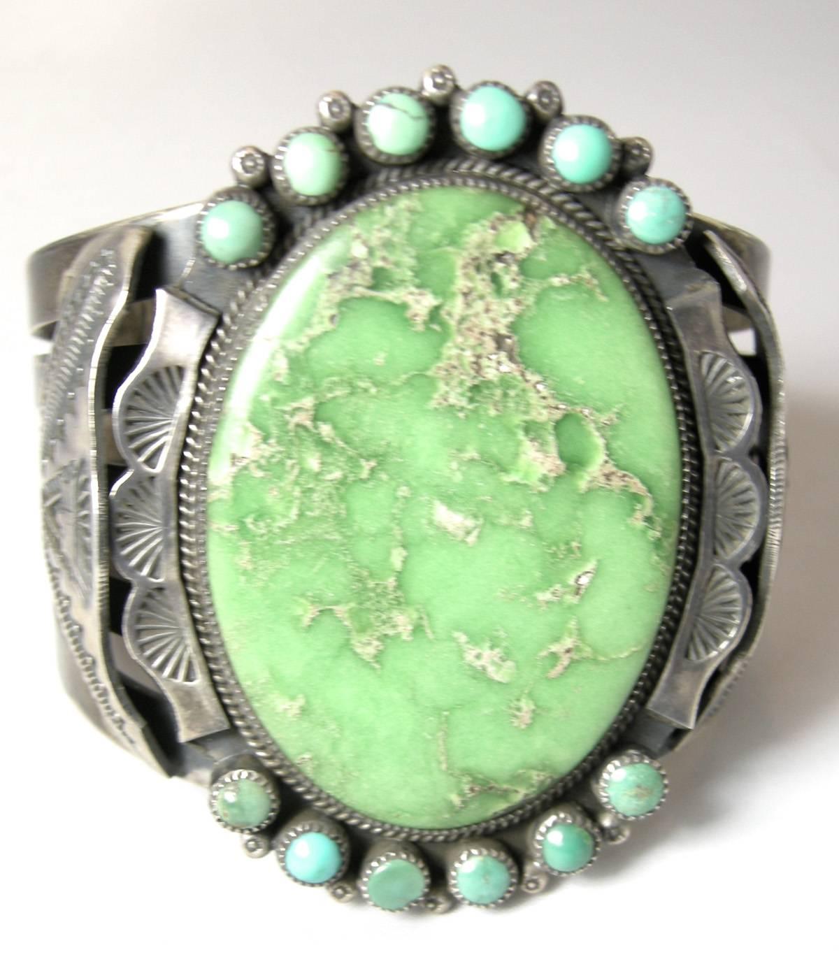 This wonderful vintage sterling silver Navajo cuff has a large green oval center and accented with turquoise round beads on each end.  The workmanship on this cuff is superb with etched wings on both sides.  It is 2-3/4” high and 2-1/4” wide.  The