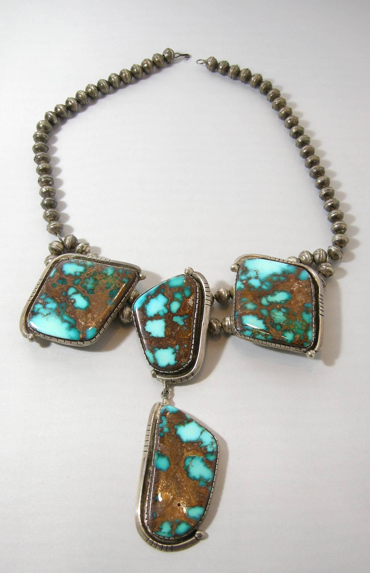 This is a very rare necklace because of the Morenci Turquoise stones.  It has sterling silver beads leading down to the main centerpiece where the back is double beaded.  The centerpiece three different shaped Morenci stones bezel into an ornate