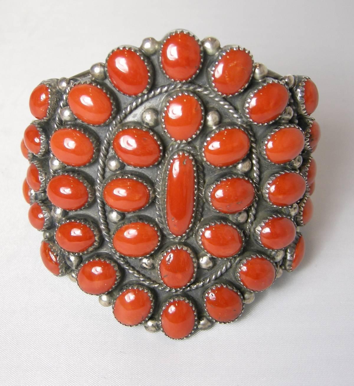 This large blood red coral cuff has graduated coral stones at the end and the larger oval shaped coral stones leading to the center where there is an oblong blood red coral stone.  All the stones are bezel set in sterling silver.  The height is