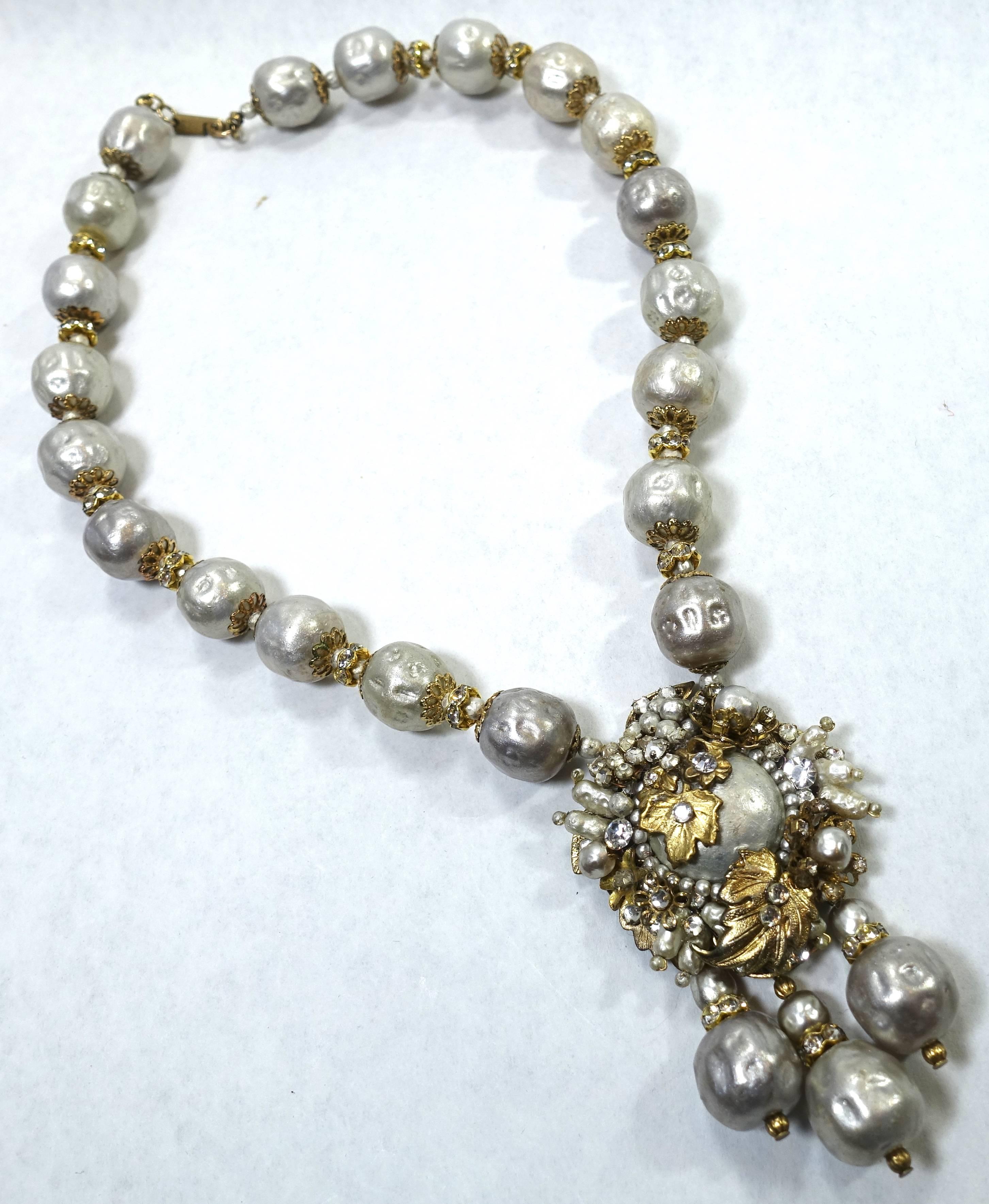 This vintage signed Miriam Haskell necklace features baroque faux pearls with rose montee stones in a gold tone setting.  This necklace measures 17-1/2” x 9/16” with a slide clasp.  The drop is 3” long x 1-3/4”.  This necklace is signed “Miriam