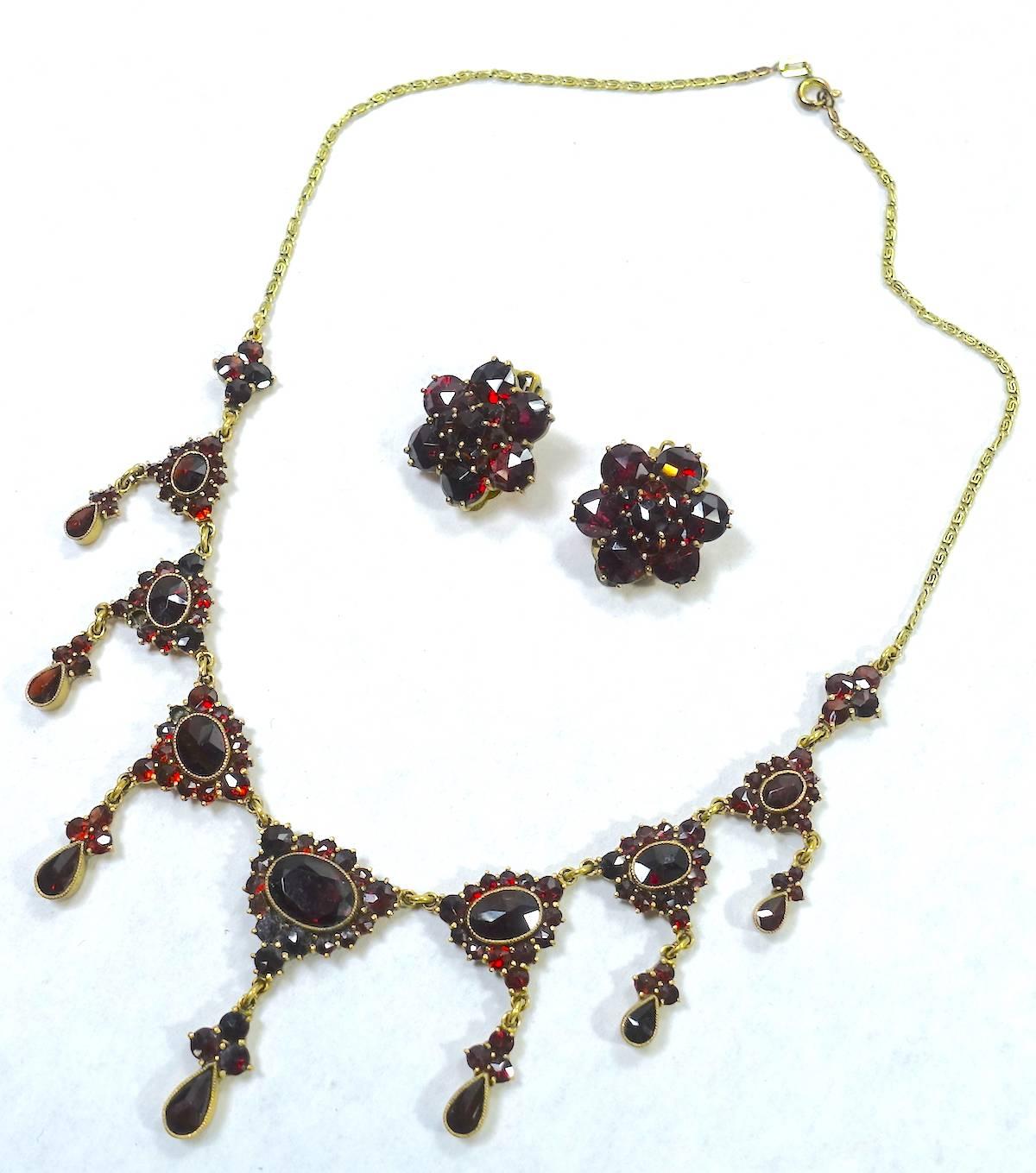 This amazing vintage Art Deco 1920s necklace & earrings must have been sitting in a collector’s drawer. It is absolutely beautiful. It features real garnet stones in a gold-plated setting.  The necklace measures 15” long with a spring closure.  The