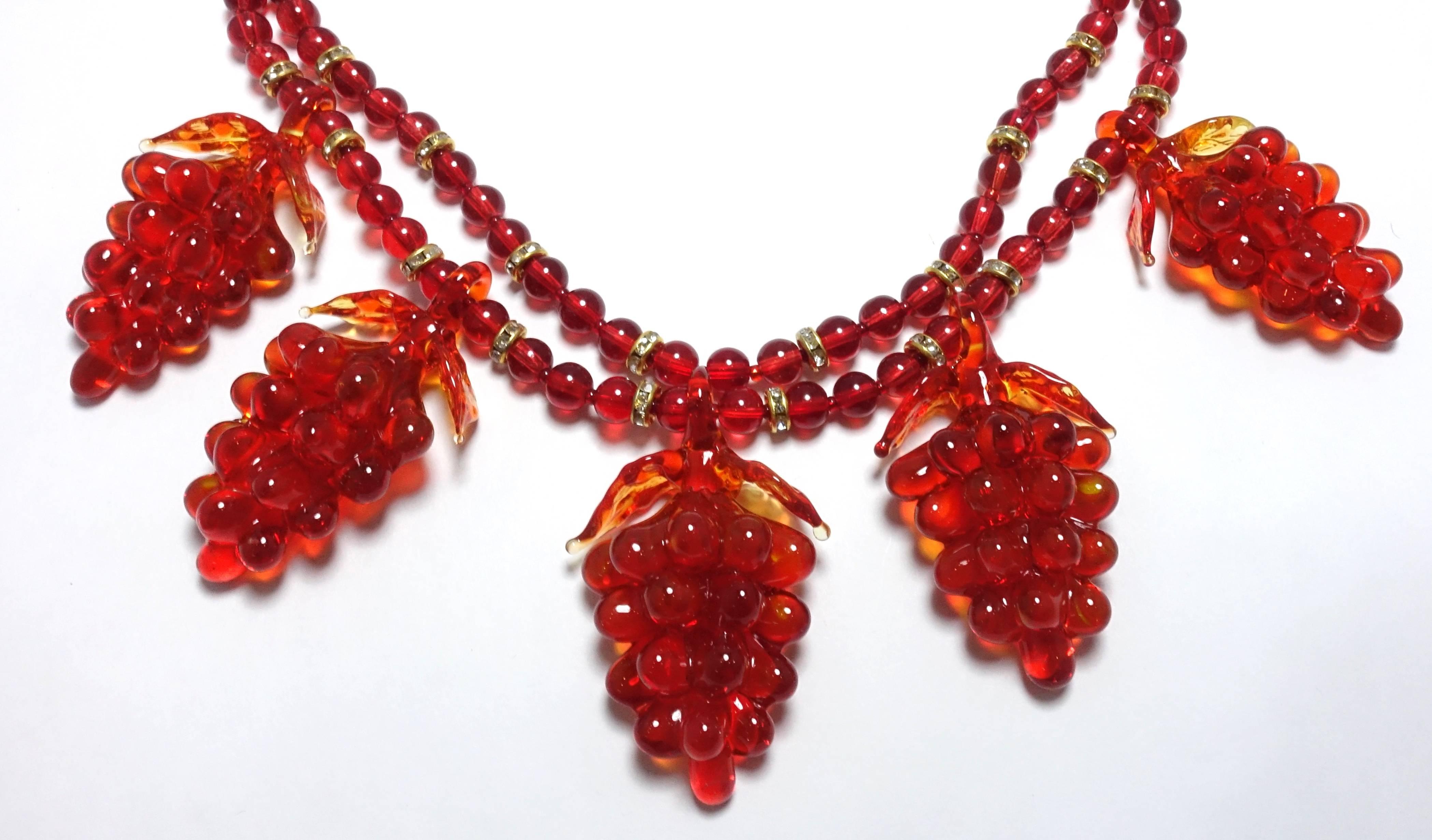 This necklace is amazing.  It is made with old red Czech glass from the 1930s.  There are two strands of red glass beads with Rondell dividers throughout the strands.  On the bottom strand, there are 5 glass grapes clusters hanging down.  It has an