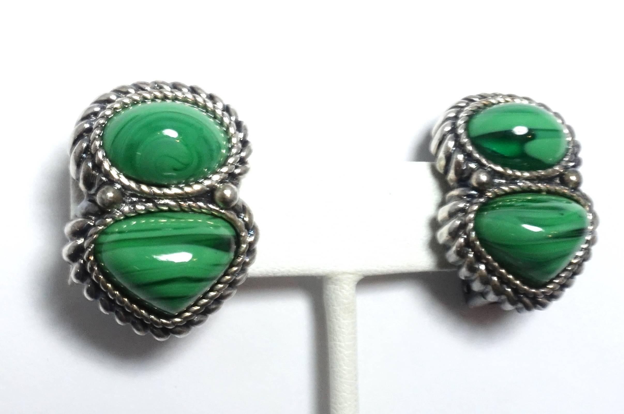 These clip earrings are in a silver tone metal setting with two faux malachite stones.  They have a ribbed border and falls nicely on the ears.  They measure 1-1/8” long and 7/8” wide.  They are signed “David Grau” and in excellent condition.
