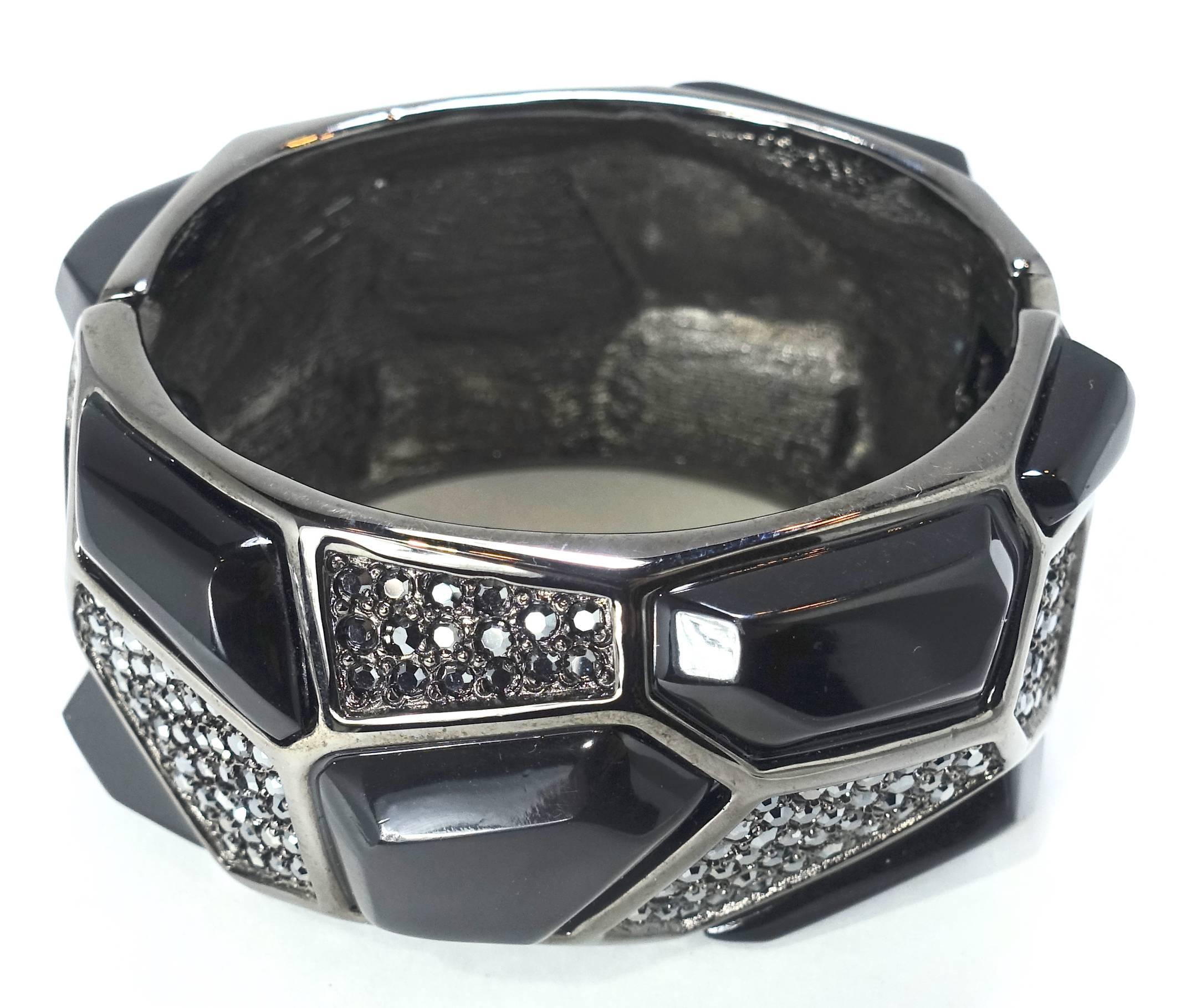 This Kenneth Jay Lane clamper bracelet has large different shaped black stones with black rhinestone accentuating the bracelet inn-between in a Japanned setting.  This clamper bracelet measures 6-1/2” around the inside x 1-5/8” wide and is signed
