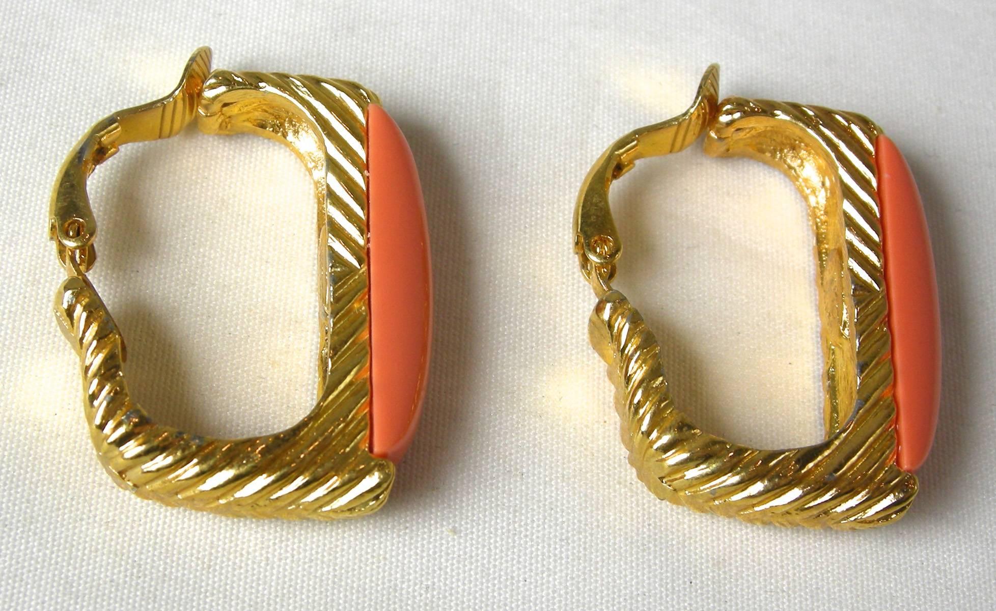 These Kenneth Jay Lane clip hoop earrings have a long faux coral front, which lies on a gold tone ribbed design.  It measures 1-1/4” long x 3/4” wide.  It is signed “Kenneth Lane” and is in excellent condition.