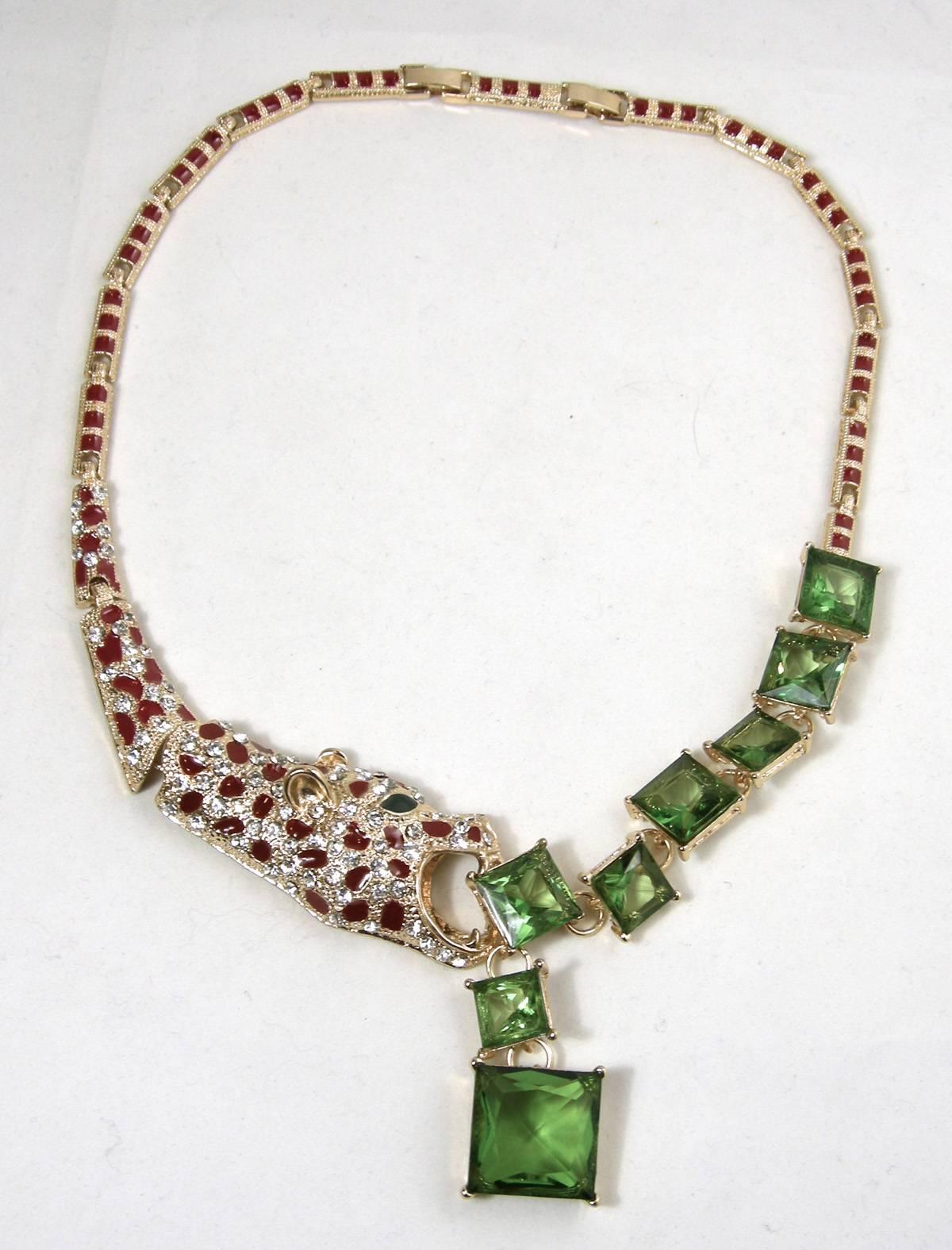 Ever see a leopard trying to eat green crystals? Well, here it is!  Made of with a gold tone base metal, the leopard’s mouth is open capturing green crystal squares. The links to this necklace has the leopard’s body is encrusted with rhinestones