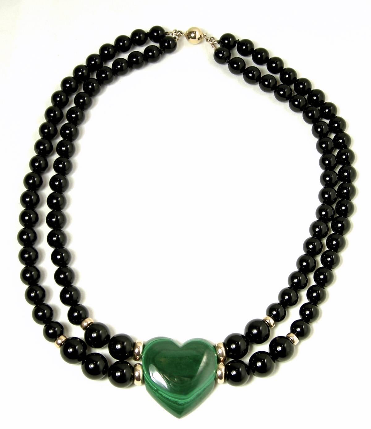 What an unusual find this is!  It has two rows of black onyx beads with a 14KT gold slide-in clasp and 14 KT gold spacers at the end of the necklace, which leads to a beautiful green malachite heart.  The necklace is 16” long.  The heart is 1” wide