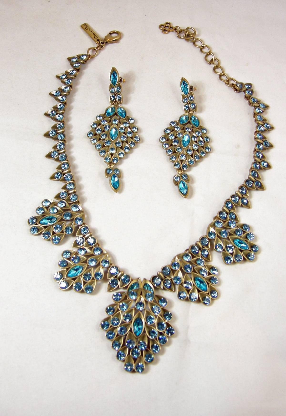 This beautiful Oscar de la Renta set is gorgeous to the eye and even more beautiful on.  It’s created in an antique gold tone finish with the open link chain at the top peacock/aquamarine color teardrops leading downward where there are two larger