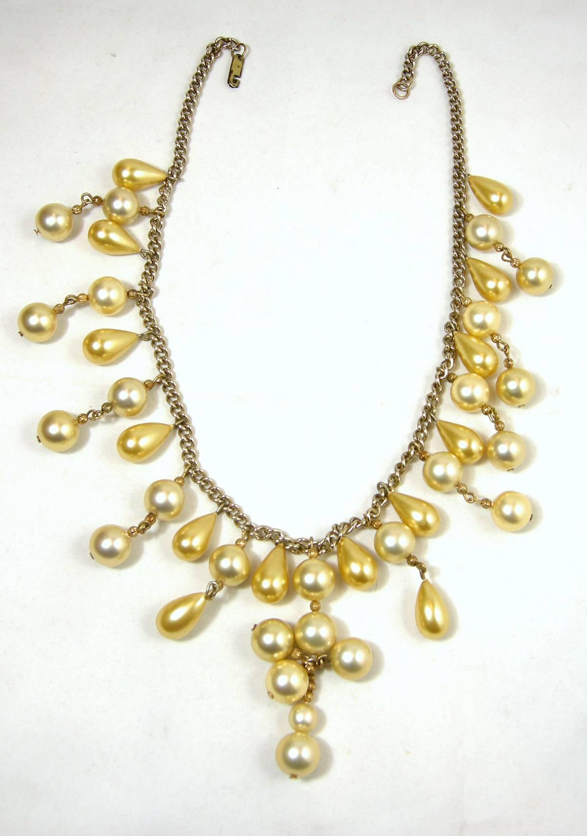 This vintage faux golden pearl bib necklace is from the 1930s.   The golden pearls are very desirable and these pearls have a mixture of round and tear-shaped connected to a gold tone chain.  It has the old-fashioned slide-in lock clasp from the 30s