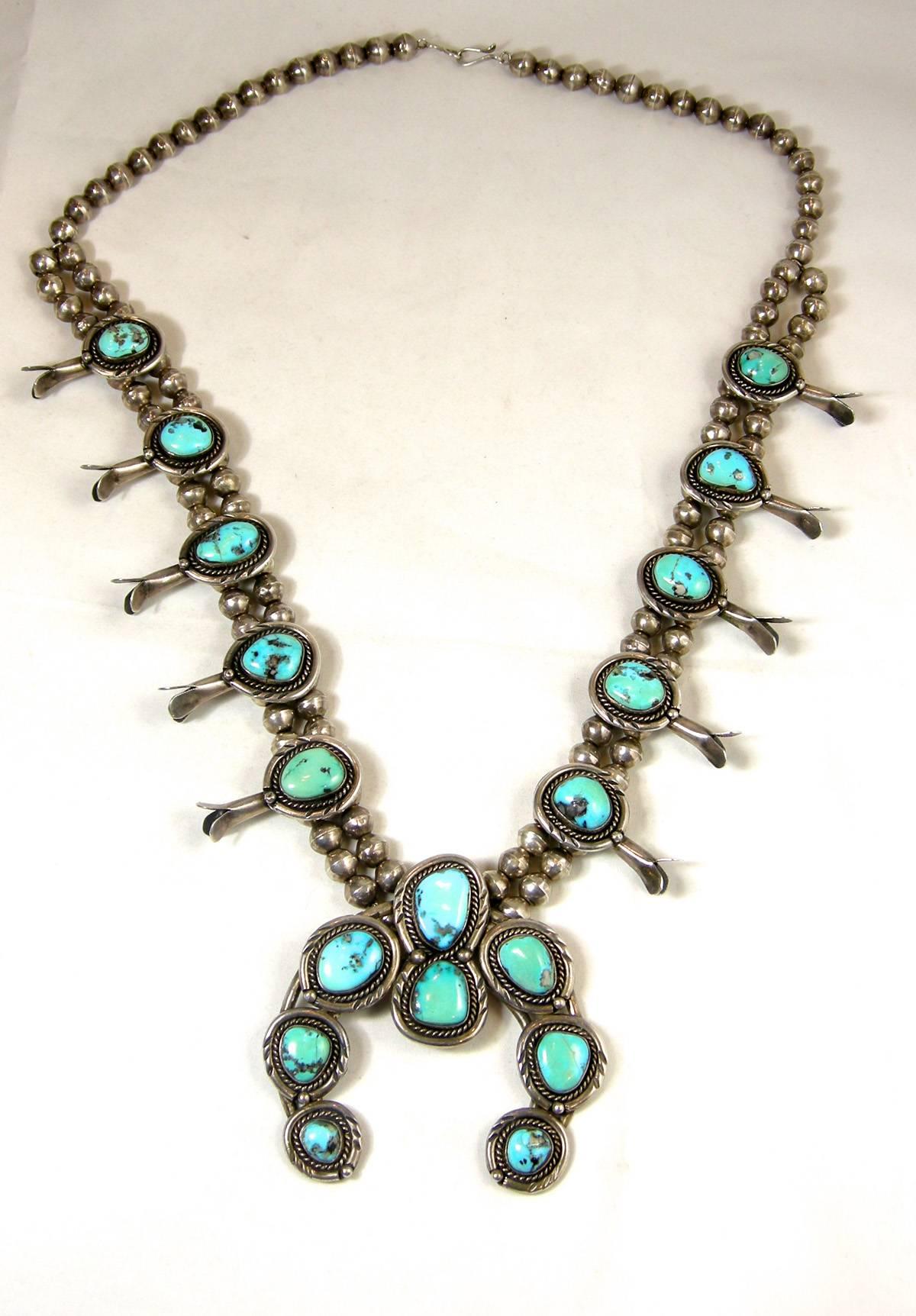 This is an exceptional sterling silver Indian Pawn squash necklace with magnificent authentic turquoise. The top has a hook clasp with a single row of sterling balls leading to a double row of sterling balls.  The entire necklace is strung with