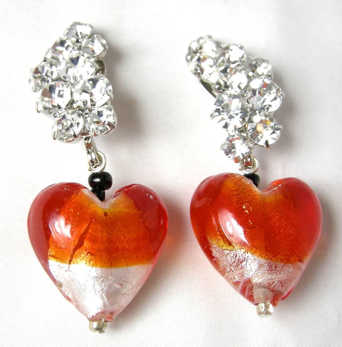 These wonderful heart shaped clip earrings by Robert Sorrell are very feminine.  They have a rhinestone cluster that extends down to an orange and clear hand blown heart shaped glass drops. Each heart is slightly different since each one is hand