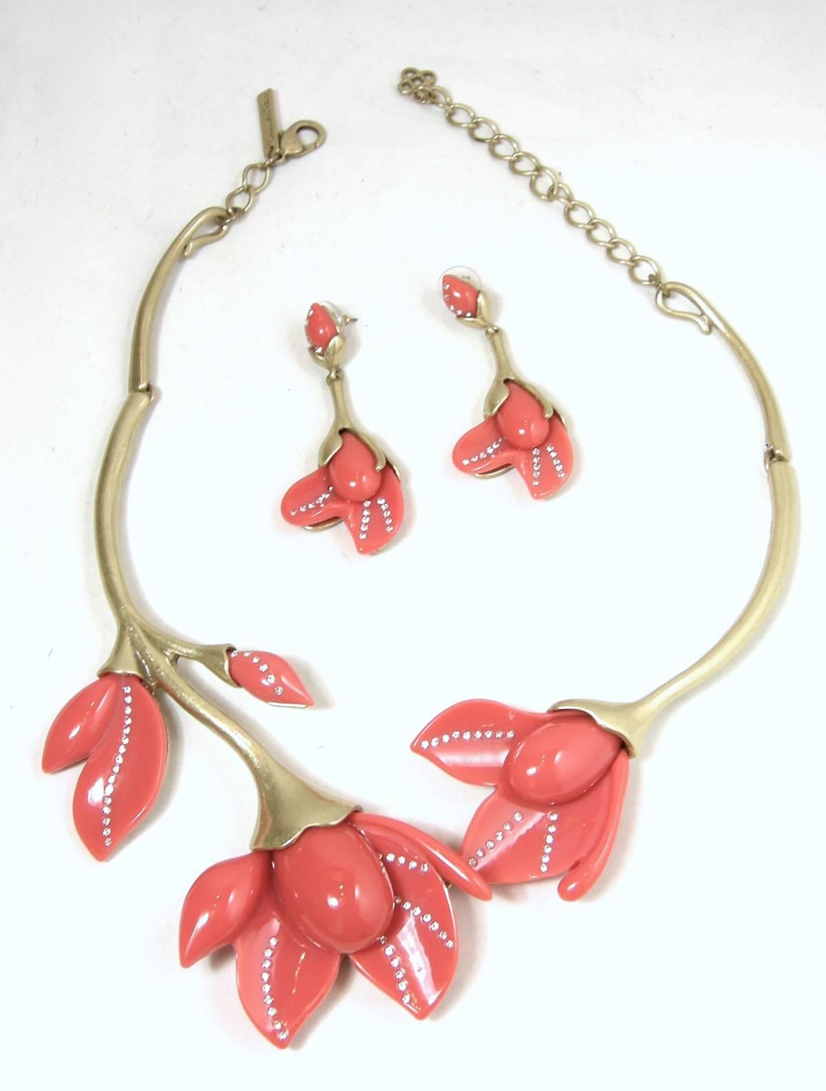 This vintage signed Oscar de la Renta necklace features pink Lucite orchids with clear rhinestone accents in a gold-tone metal setting.  This necklace measures 20” long with a spring closure x 2-1/2” wide at the centerpiece. The necklace is signed
