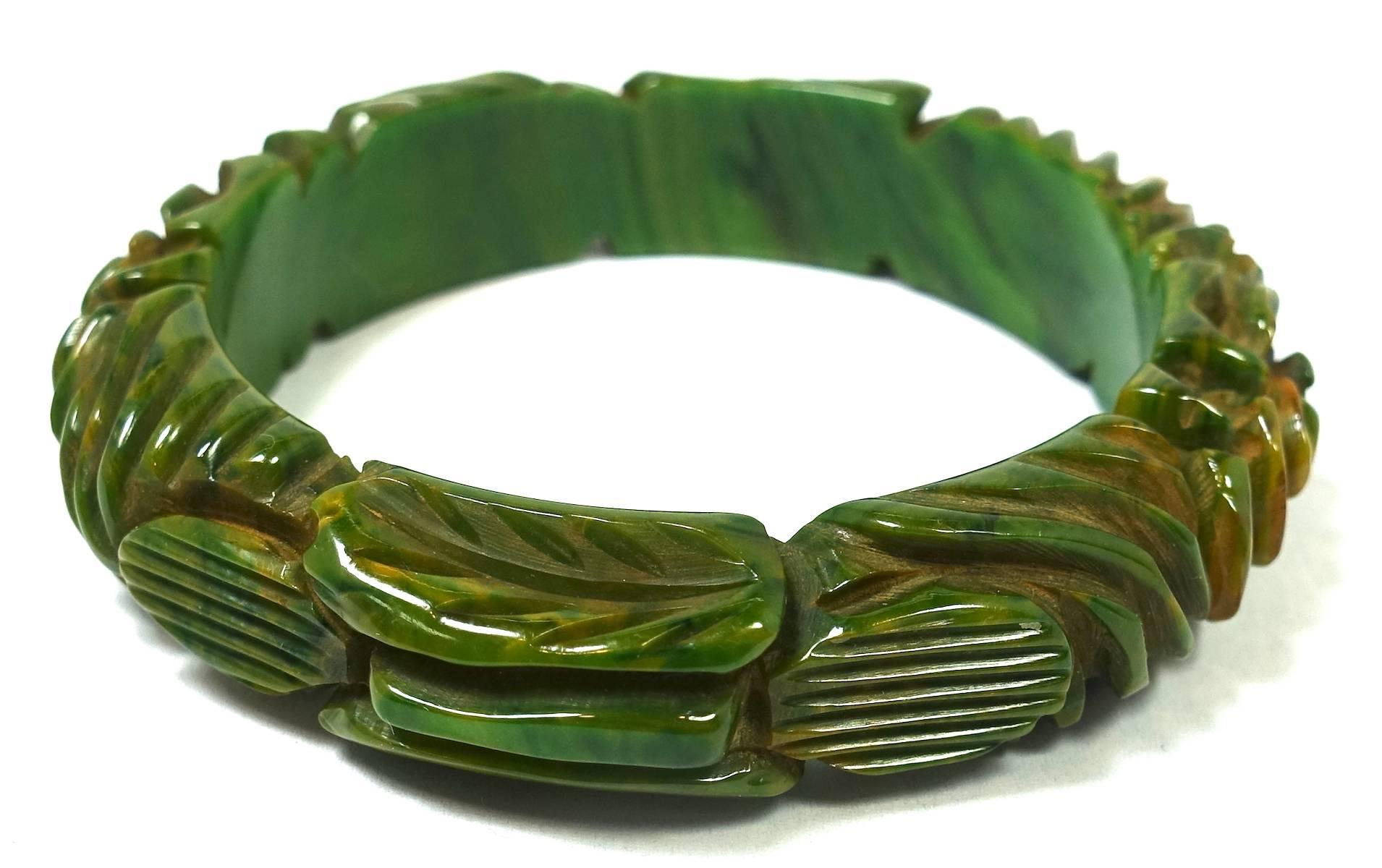 This is a gorgeous, heavily carved Bakelite bangle bracelet in green with hues of rusted coral overall.  This piece measures 7-3/4” x 5/8” and is in excellent condition.