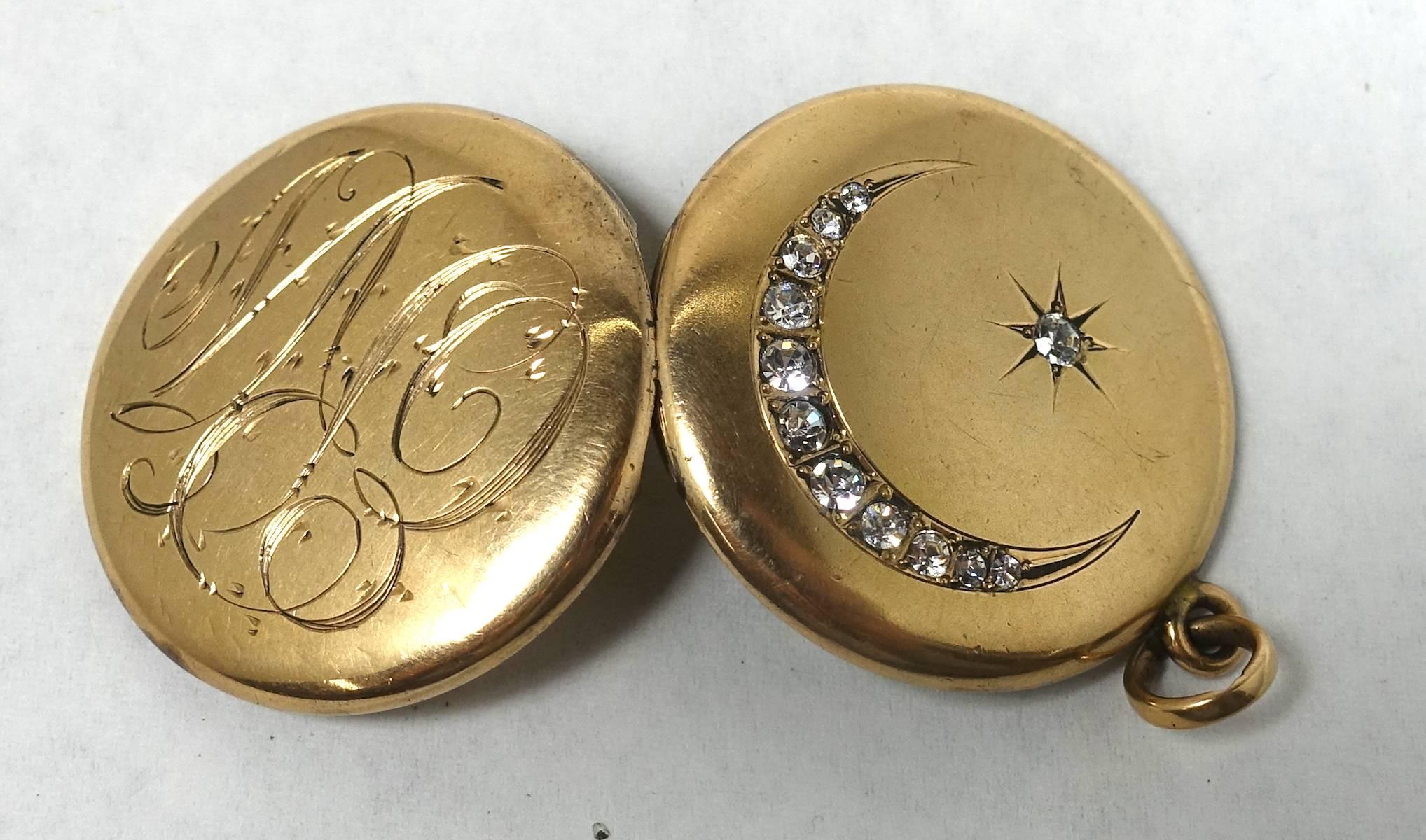 This signed W&M Co. vintage locket features a half moon and star in clear crystals. It is in a gold filled setting.  On the other side, there is an elaborate engraving, which we can’t make out.  This locket measures 1-1/8” in diameter and is signed