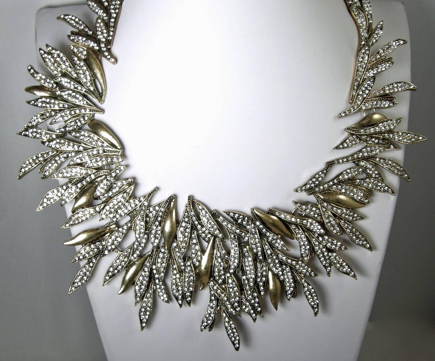 This elegant Oscar de la Renta is an important statement necklace. It is designed in an intricate motif of cascading Austrian crystals leaves in a gold tone setting. It is simply dazzling with its fabulous pave crystal leaves. The necklace lays