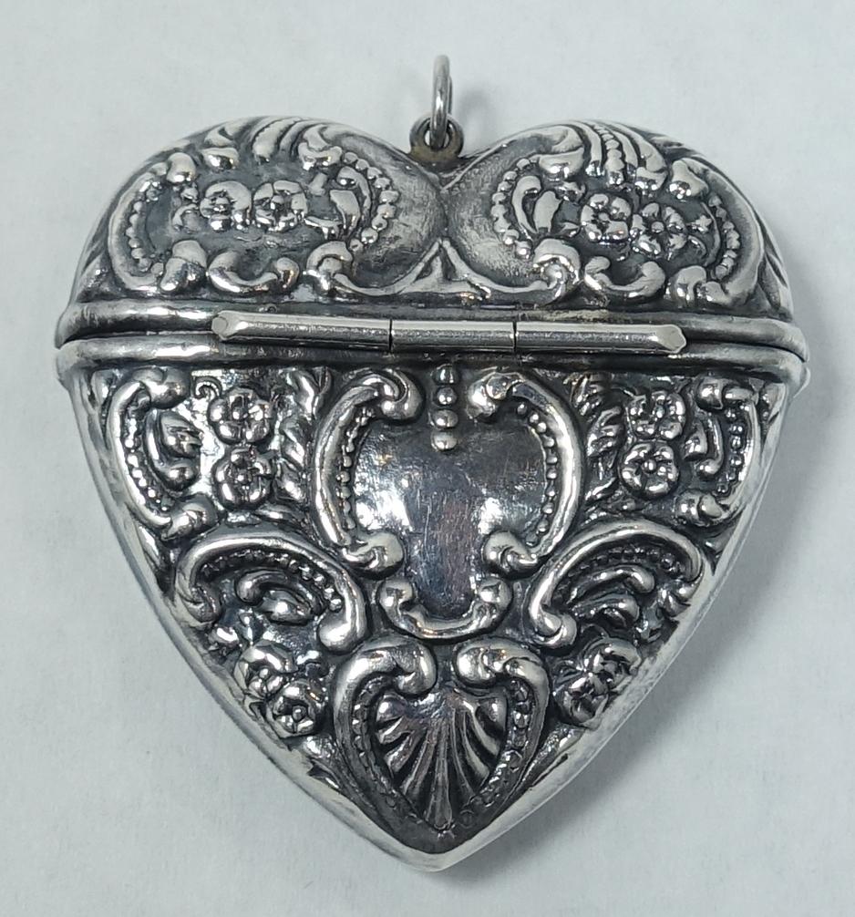 This detailed vintage sterling silver pillbox pendant has a heavily carved heart design.  This piece measures 1-5/8” x 1-1/2” and is in excellent condition.
